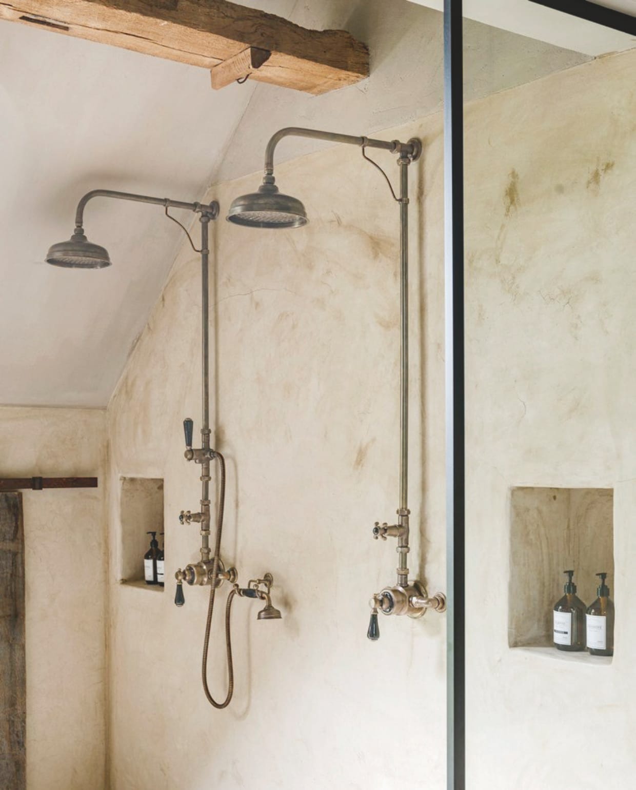 Dubbele douche in verouderd messing met zwarte porseleinen details van Taps & Baths. vtwonen Landelijk 05-2026 | productie Tabs & Baths | fotografie Claude Smekens
