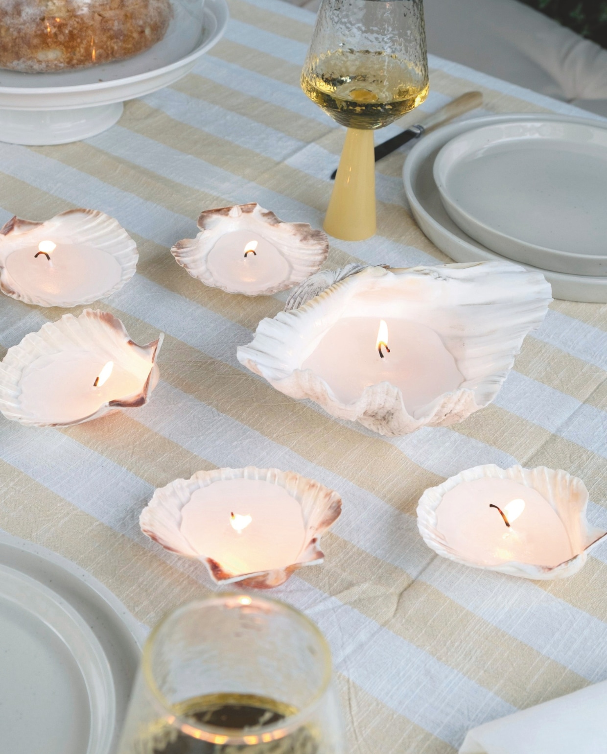 Tafelkleed van Oyoy en wijnglazen van Brût Homewear via vtwonen.nl/shop. Gespikkeld servies en stolp Dille & Kamille. Tuinstoel Fatboy. Bestek kringloop.