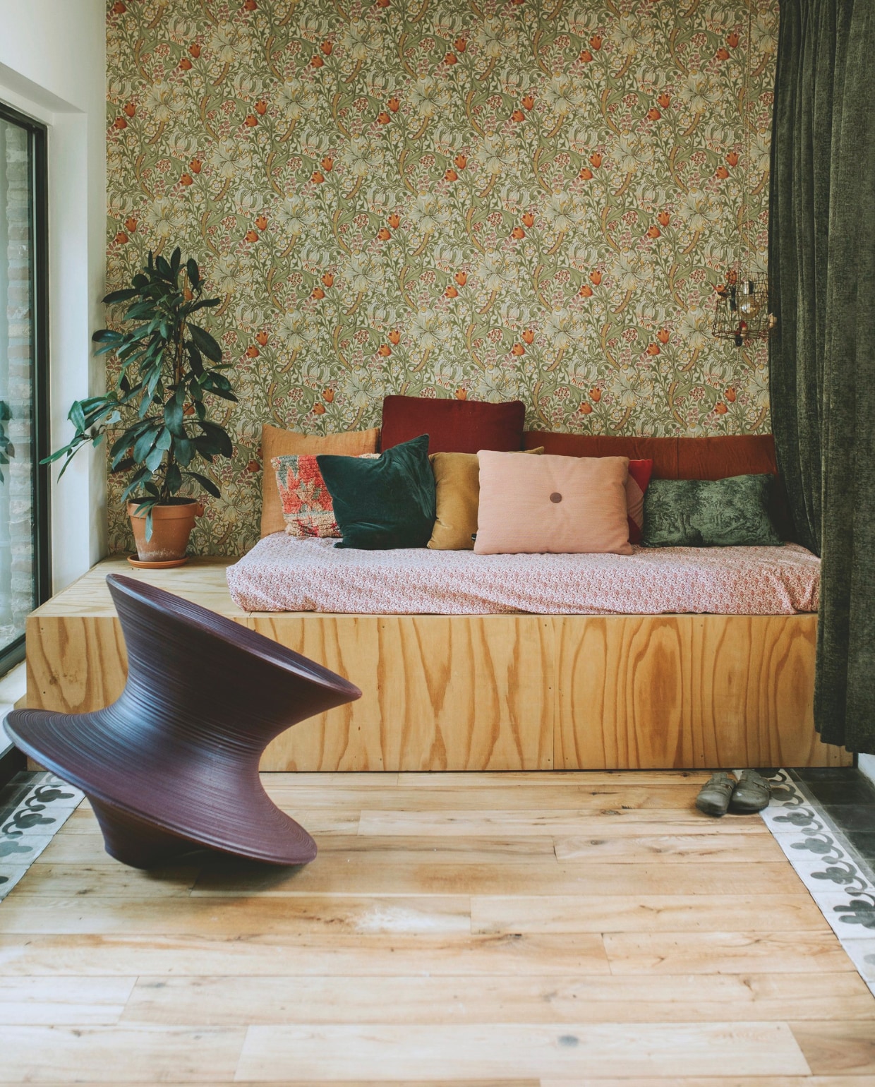 Behang Lily van William Morris. Vloertegels van oud bouwmateriaal. Vloer hergebruikt parket. Bank zelfgemaakt. Stoel Magis. Sprei zitkussen Ikea. Kussens Loods 5, The Souks, Ikea, Sissy-Boy, HKliving, Hay, Festen Maastricht, Karwei. Gordijnen Karwei. vtwonen zomerspecial 2026 | styling Puck Hommerter, Eva Krebbers | fotografie Eva Krebbers (Tumbleweed & Fireflies Photography)