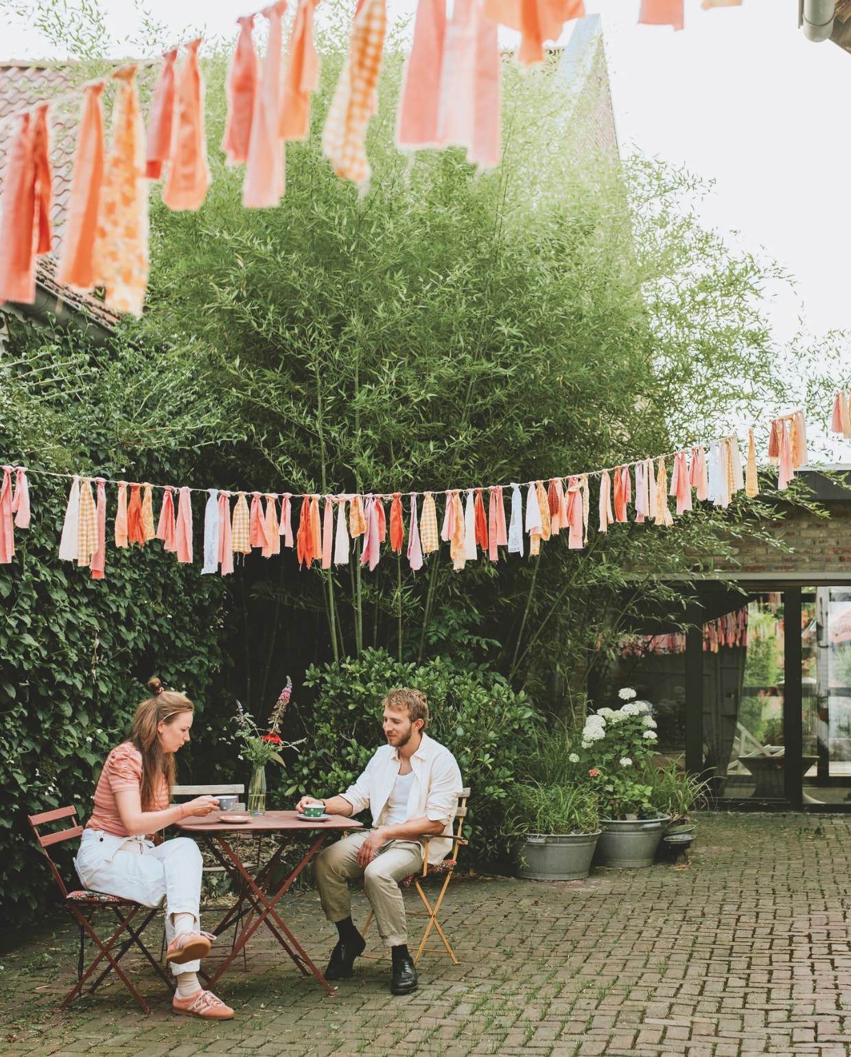 Slingers zelfgemaakt. Tafel en stoelen Marktplaats. Kop-en-schotels brocante. Plantenbakken kringloop. vtwonen zomerspecial 2026 | styling Puck Hommerter, Eva Krebbers | fotografie Eva Krebbers (Tumbleweed & Fireflies Photography)