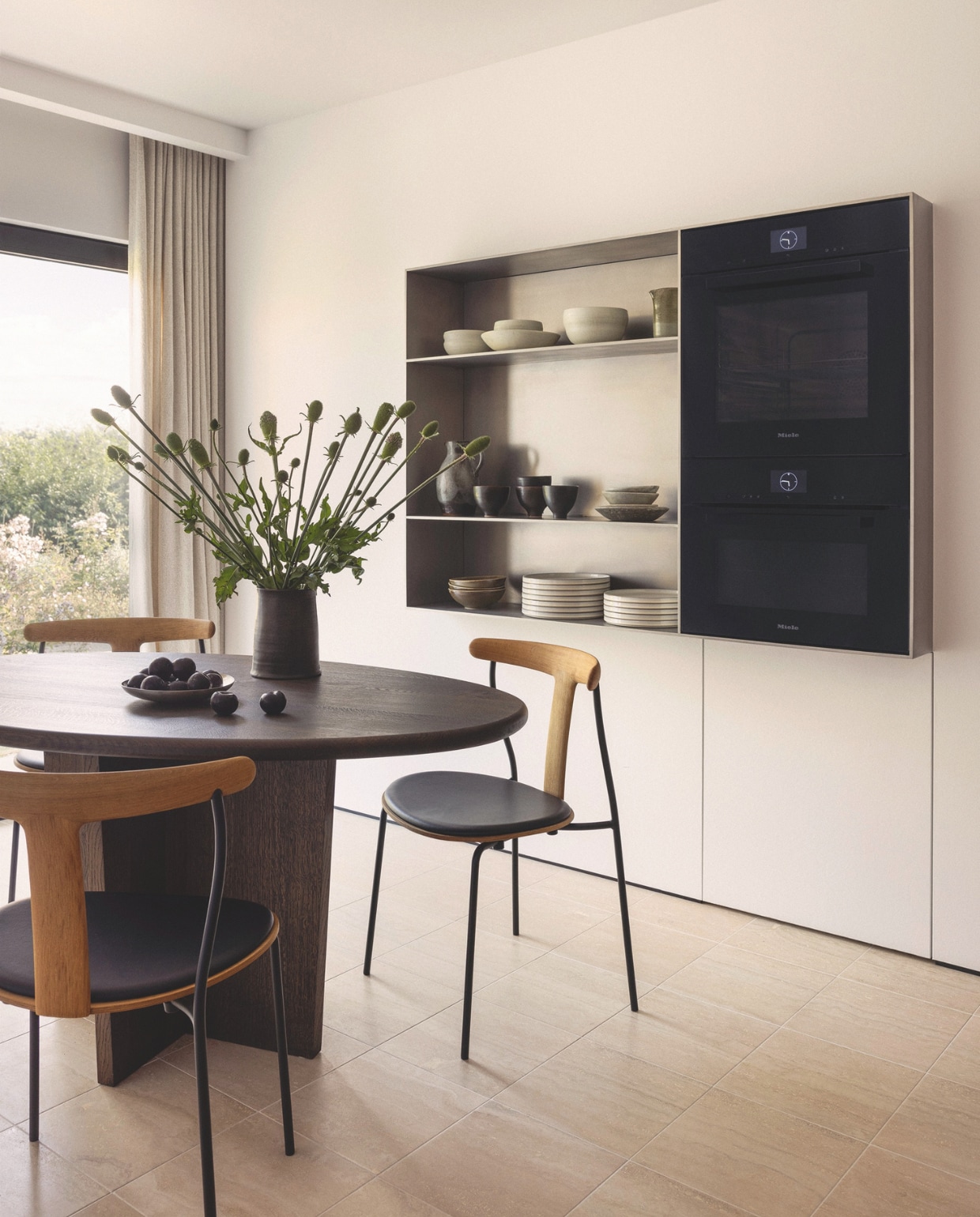 Tafel maatwerk via Heerenhuis. Scandinavische eetkamerstoelen, merk onbekend. Ovens Miele. Inbouwkast ontworpen door Stef Claes en op maat gemaakt. Aardewerk via Items by Bea. vtwonen Design 04-2026 | fotografie Eric Petschek