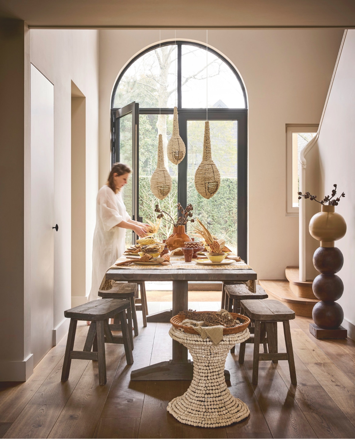 Aura Peeperkorn kloostertafel, hout, 240x100x75 cm (lxbxh) € 1629-,-, krukken, hout, 60x30x43 (lxbxh), per stuk € 165,- (aurapeeperkorn.com). Lampen Birdnest, kleikralen, per stuk € 350,-, kruk, kleikralen € 1753,-, Wonki Ware dinerborden, keramiek, geel, per stuk € 32,50, Wonki Ware soepkommen, geel, per stuk € 27,50 (mvninteriors.com). Op tafel Élitis stof Alma, geïnspireerd op Indiaanse borduurwerk, ambachtelijk vervaardigd in België, polyacryl, katoen, wol en pes, per meter € 135,- (elitis.fr). Urban Nature Culture vaas Cody, keramiek € 79,99, Urban Nature Culture pedestal Bulb, mahoniehout, 28x82 cm (Øxh) € 299,-, daarop Urban Nature Culture vaas Pot Ilo, keramiek, beige € 169,99, Household Hardware mok, keramiek € 9,95, Household Hardware zigzag kom, keramiek € 9,50, Household Hardware zigzag bord op voet, wit, € 39,95, Household Hardware lepel, harirahout € 7,50 (shop.vtwonen.nl). Zara bestek, esdoornhout en rvs, 4-delig € 29,99 (zarahome.com). Couleur locale schaal Illala op kruk, illalapalm, € 255,- (couleurlocale.eu). Overig privébezit. vtwonen Landelijk 05-2026 | styling Kelly van Gendt en Liza Wassenaar | fotografie Alexander van Berge