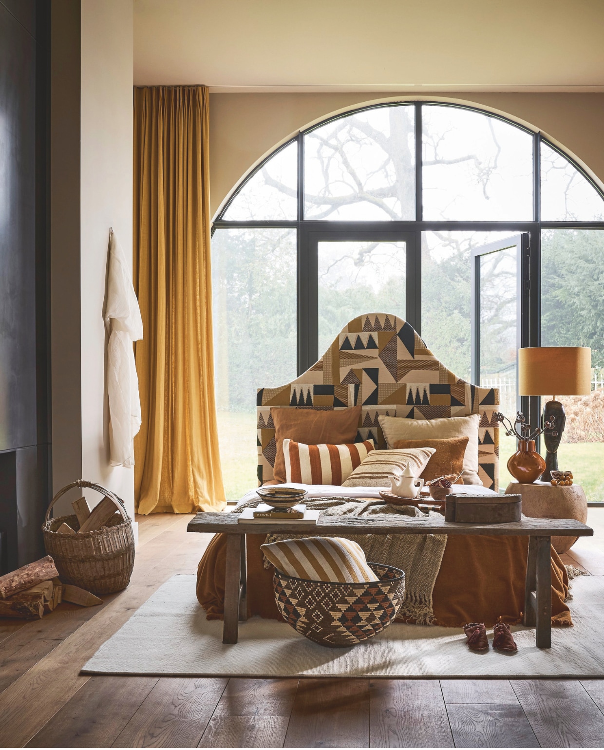 Combitex op maat gemaakt hoofdbord, prijs op aanvraag (com-anders.nl), bekleed met Élitis stof Continent, polyester, katoen, linnen en nylon, per meter € 280,- (elitis.fr). Couleur locale oude Chinese plukmand, rotan € 169,-, mand Cone, ambachtelijk geweven, illalapalm € 760,-, kelim kussen, handgeweven, geel € 55,-, kelim kussen, handgeweven, gestreept € 55,-, schaal Illala, illalapalm € 255,-, Maison de Vacances plaid Visa Versa, gewassen linnen € 220,-, kruk Tambour, palmhout € 650,- (couleurlocale.eu). Beni Ouarain vloerkleed, wol, 195x310 cm (lxb), prijs op aanvraag (rozenkelim.nl).  Aura Peeperkorn kralendoos, hout € 74,50, bankje, hout, 160x40x40 cm (lxbxh) € 429,- (aurapeeperkorn.com). Madam Garage tafellamp Charcoal Wooden Face, hout en zijde € 588,- (madamegarage.nl). Household Hardware kussen, mosterd, grote streep € 95,-, kom, walnoothout € 17,95, zigzag kom, keramiek € 9,50 (householdhardware.nl). Zara Home tweedelig nachthemd, lyocell, polyamide, viscose en polyester € 69,95 (zarahome.com). Japanse theepot, keramiek, prijs op aanvraag (japansetheepot.nl). Overig privébezit. vtwonen Landelijk 05-2026 | styling Kelly van Gendt en Liza Wassenaar | fotografie Alexander van Berge
