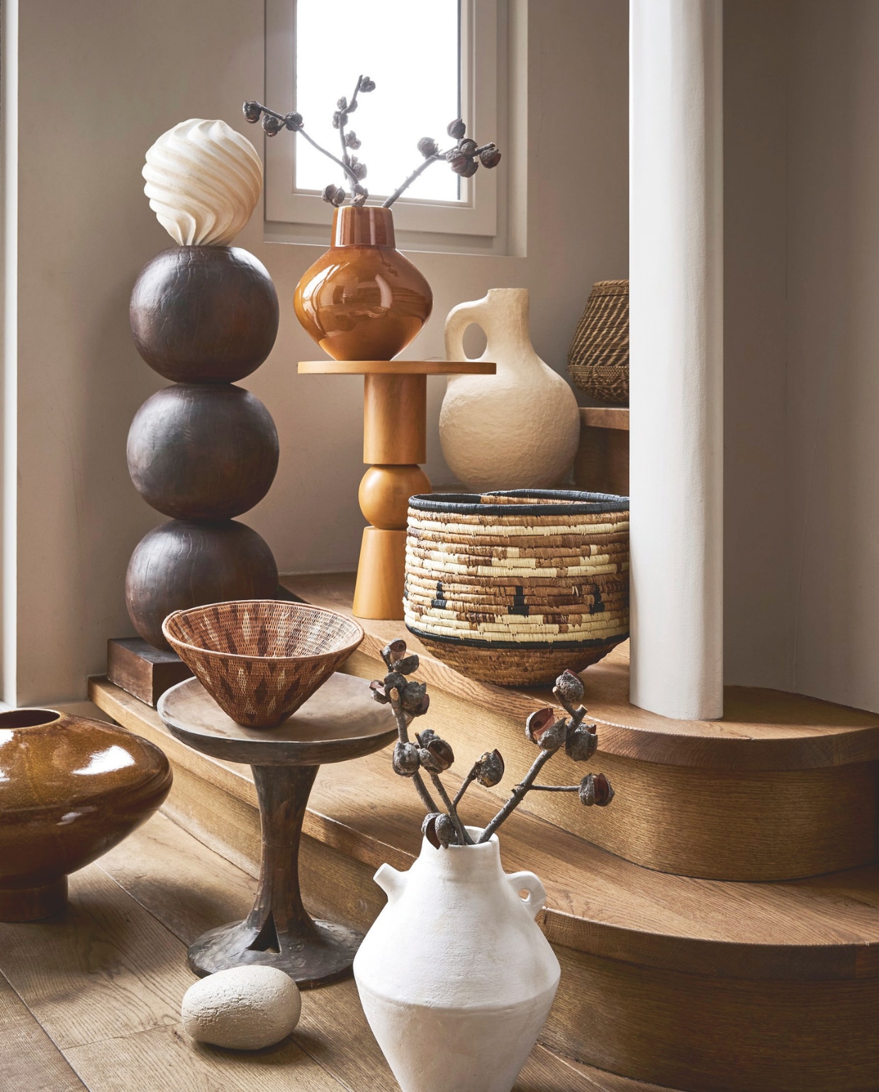 Urban Nature Culture sidetable Teko, mangohout, oranje, 35x42 cm (Øxh) € 269,99 vaas Cody, keramiek, golden brown € 79,99, vaas Nala, keramiek, bruin, 37,5x24,4 cm (bxh) € 149,99, vaas Pico, terracotta, wit, 22,4x28 cm (Øxh) € 99,-, vaas Pot Gigi, met oor, katoen-maché, sand € 119,- (shop.vtwonen.nl). Urban Nature Culture pedestal Bulb, mahoniehout, 28x82 cm (Øxh) € 299,- (urbannatureculture.com). Coulour Locale mand Lozi Pot, rotan € 89,-, mand Cone € 760,- (couleurlocale.eu). Aura Peeperkorn authenthiek plateau, hout € 140,- (aurapeeperkorn.com). Atelier de Rijk rond object, prijs op aanvraag (atelierderijk.com). vtwonen Landelijk 05-2026 | styling Kelly van Gendt en Liza Wassenaar | fotografie Alexander van Berge