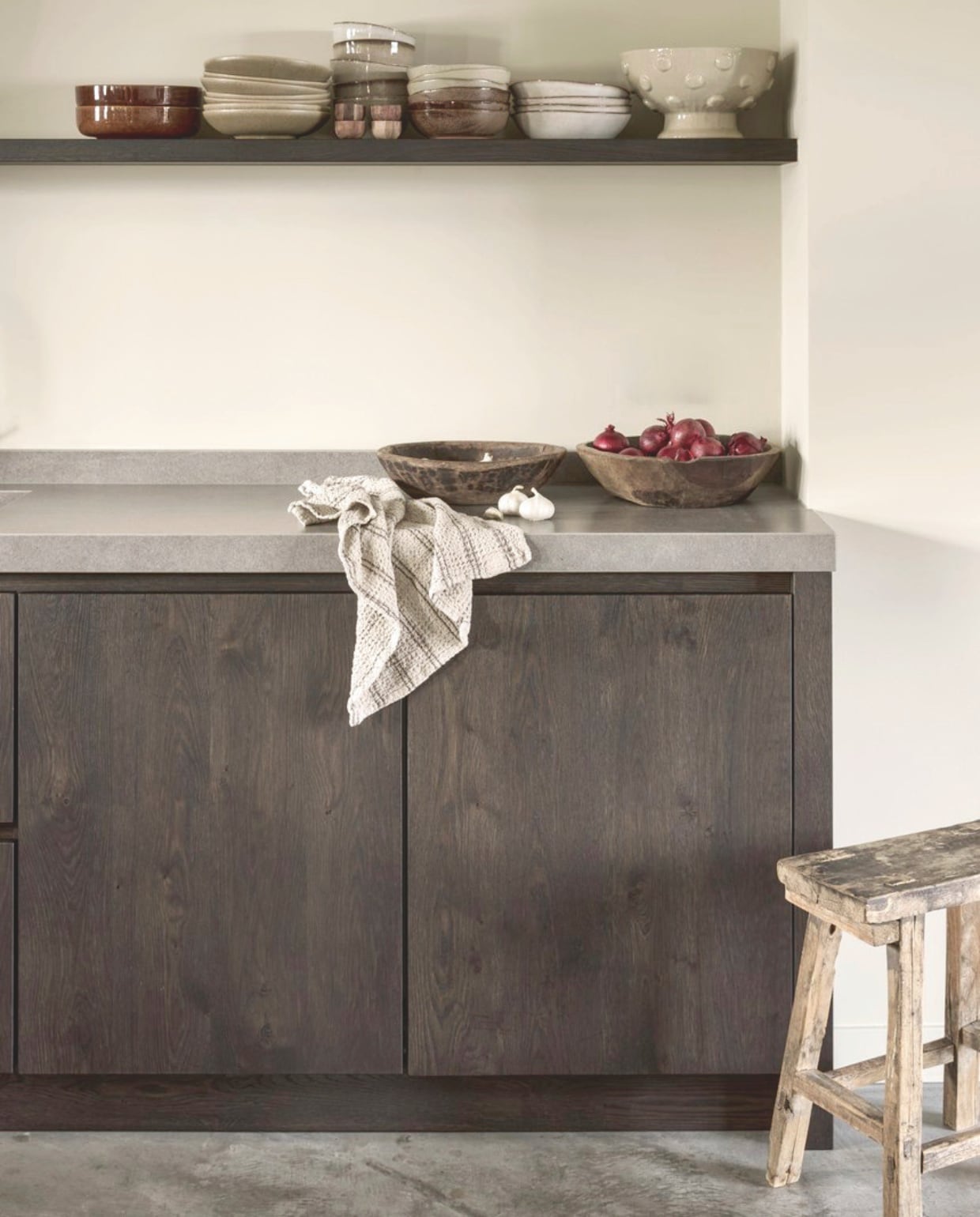 Muurkleur French Linen van Painting The Past. Vloer gevlinderd beton. Plank en keukenkleur Wengé via Ak Keukens. Houten schalen De Tuynkamer. Theedoek Nordic Nest. Kruk antiek. vtwonen Landelijk 05-2026 | styling Kristel van Leeuwen | fotografie Peggy Janssen