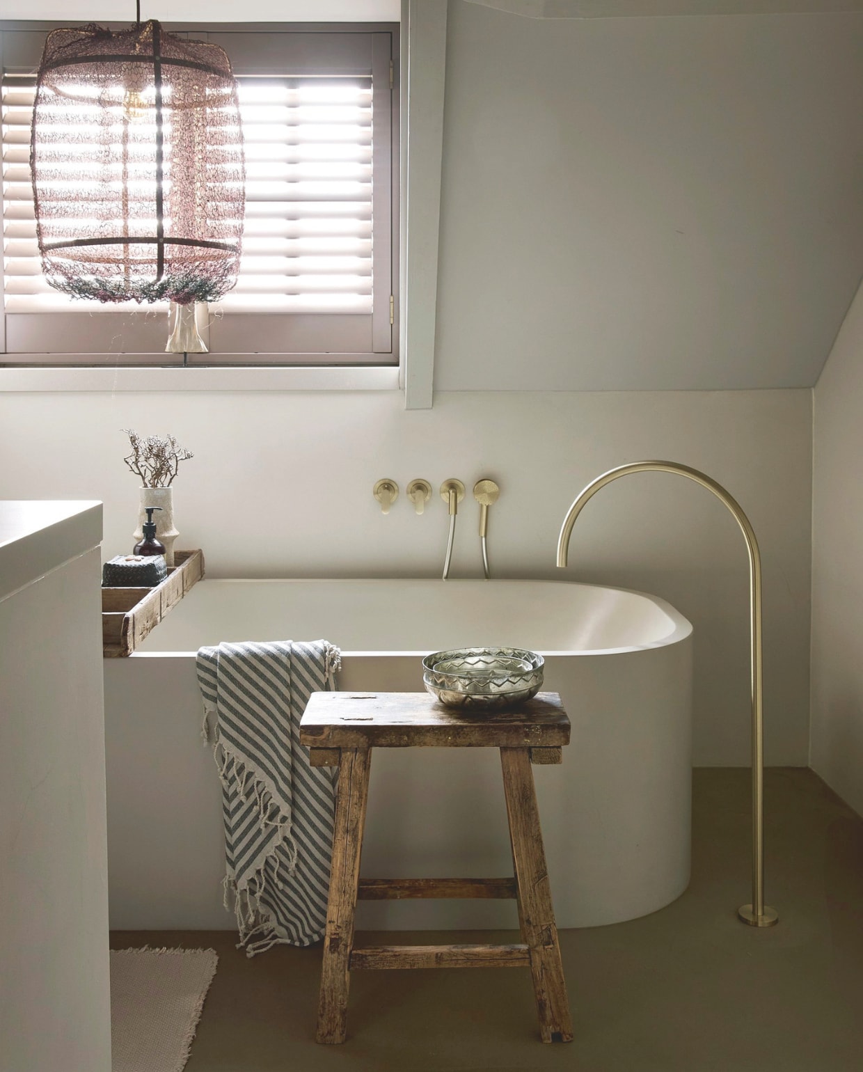 Bad en kraan John Pawson via Piet Boon. Kruk antiek. Schaal Ottomania. Hammamdoek en kleed H&m. Kleed en shutters via woon(T)huis. Hanglamp De Tuynkamer. vtwonen Landelijk 05-2026 | styling Kristel van Leeuwen | fotografie Peggy Janssen