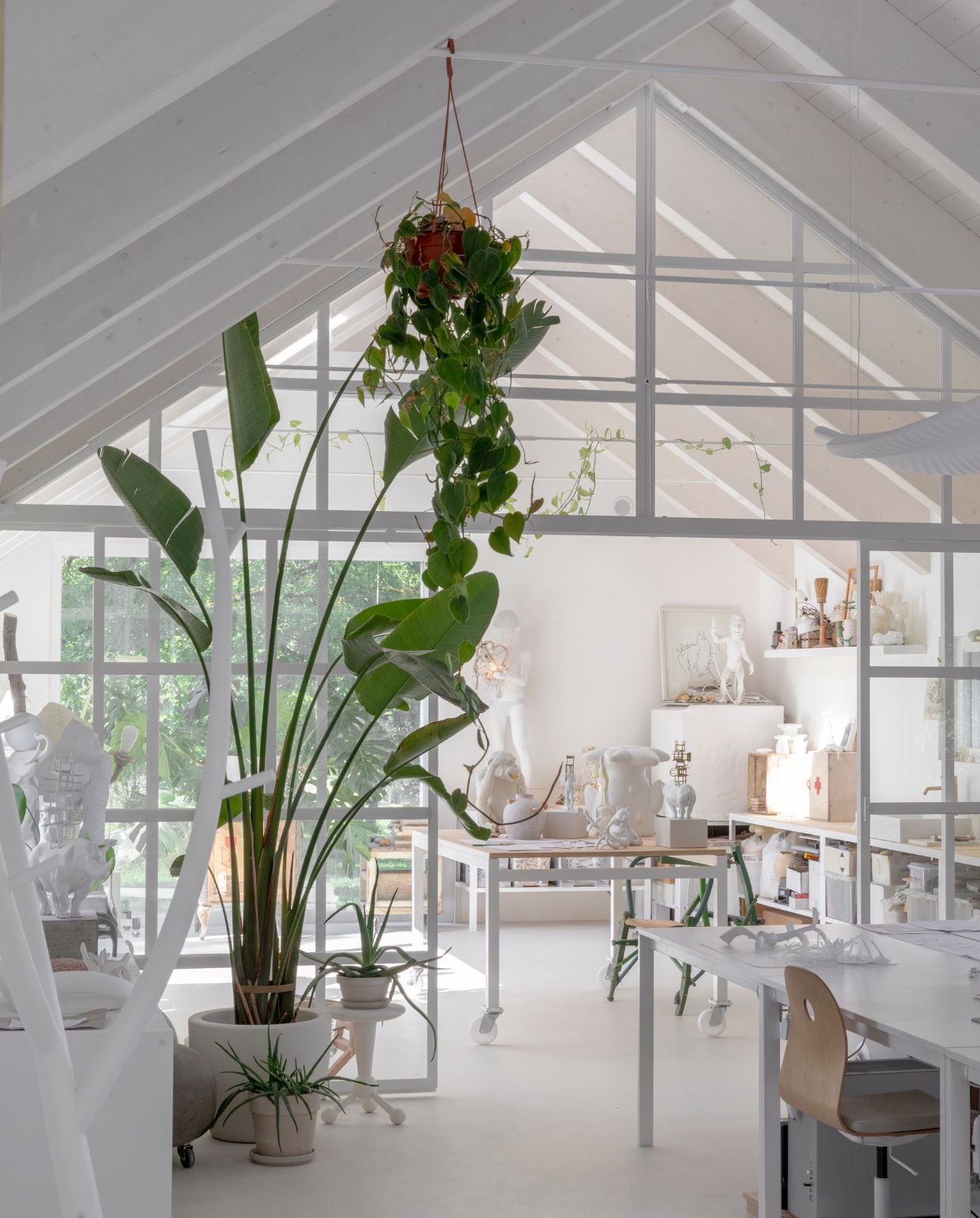 De lichte, volledig witte studio, met grote ramen en veel ruimte om vrij te creëren. Hier zie je prototypen en experimentele stukken zoals de groene stoel uit de After Chair-collectie, gemaakt van oude stoelonderdelen. vtwonen Design 05-2025 | fotografie Helenio Barbetta