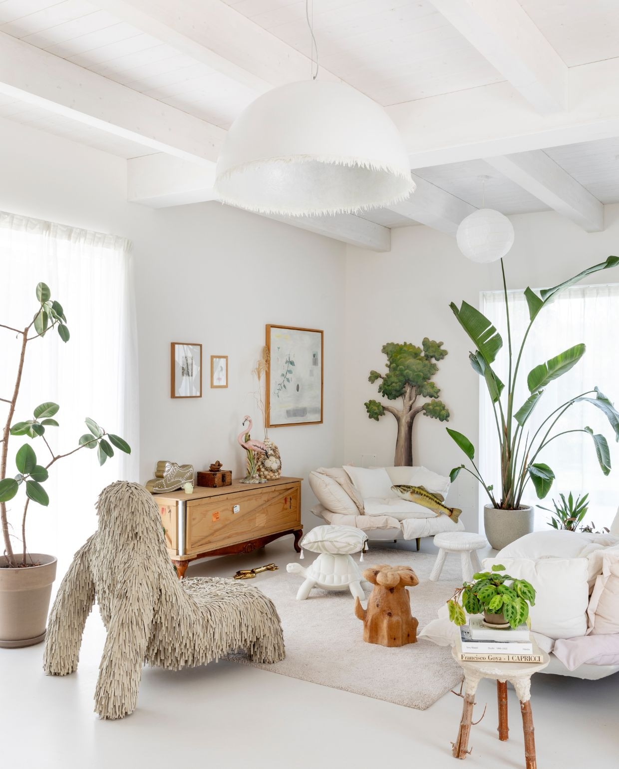 Fauteuil Gorilla van Marcantonio. voor Scarlet Splendour. De boom aan de muur stond ooit op de set van een kindershow. Fauteuil Comfy, objecten Golden Keys en kast Export Como van Marcantonio voor Seletti. Kruk Milk uit de Blow-collectie van Studio Job voor Seletti. Poef Turtle Carry van Qeeboo. Koepelvormige kroonluchter Plancton van Karman. Overige krukken van vlooienmarkten. Bloemvormige bijzettafel, bijzettafel Revenge of Beauty op de voorgrond en kussen Largemouth Bass Fish Gaby van Marcantonio. vtwonen Design 05-2026 | fotografie Helenio Barbetta
