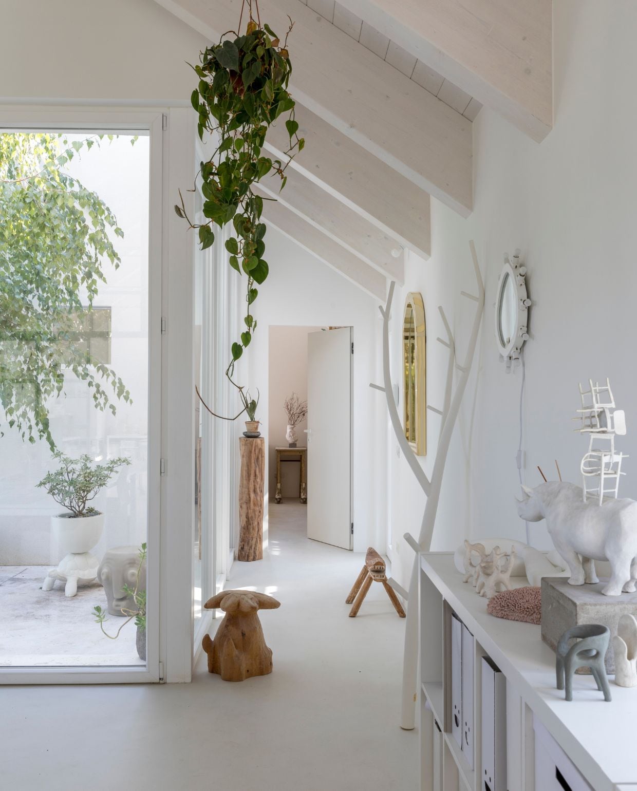 Kapstok Ramo van Opinion Ciatti. Gouden spiegel uit de Forest-collectie van Scarlet Splendour. Spiegel met lampjes Luminarie van Seletti. Kruk Fiore is een sculpturaal werk. Door het raam Threebù van Slide en Turtle Carry van Qeeboo. Op de kast Rhinoceros with Chairs, een bronzen sculptuur. Op de achtergrond in de deuropening: Tavolo con Pattini. Alles ontworpen door Marcantonio. vtwonen Design 05-2026 | fotografie Helenio Barbetta