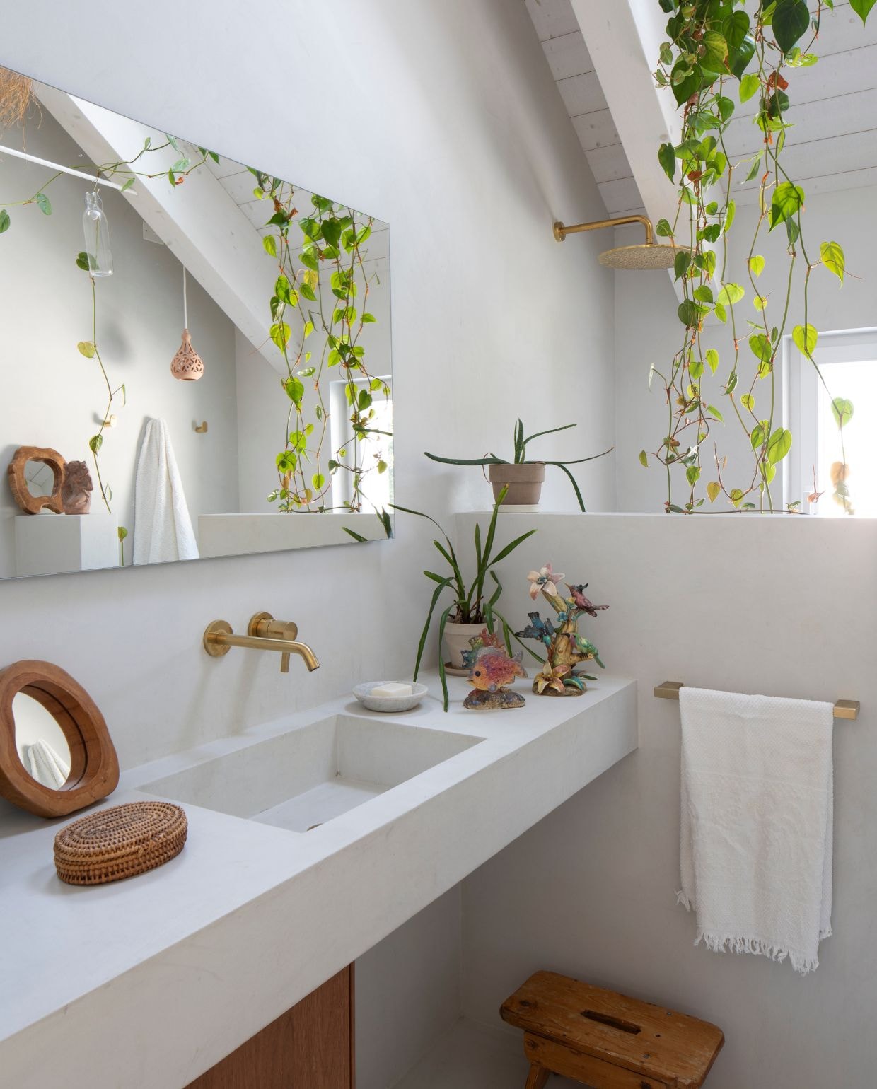 Badkamer uit de Atelier Collections van Ideal Standard met wastafelmeubel Conca met walnoten afwerking en wandmengkraan Joy, douchekop Idealrain en handdoekrek-accessoire met Brushed Gold pvd-coating. Rechthoekige Ideal Standard spiegel met Mid Ambient verlichting. Decoratie antiek- en kringloopvondsten. vtwonen Design 05-2026 | fotografie Helenio Barbetta