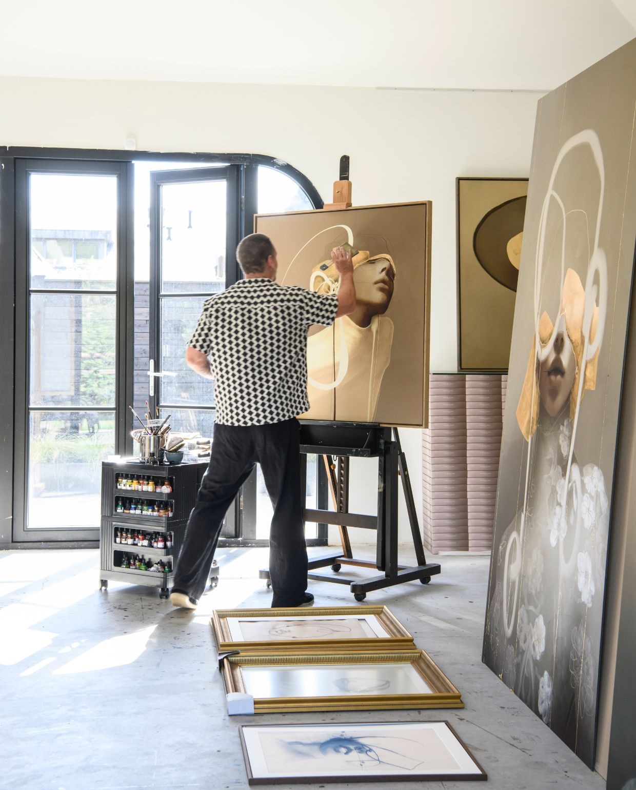 Kast op wielen en schildersezel Meeden Art Supplies. Kunst en lijsten Chris Luka. Gietvloer onbekend. Muurkleur Slipper Satin van Farrow & Ball. vtwonen 06-2026 | styling Esther Loonstijn | fotografie Louis Lemaire