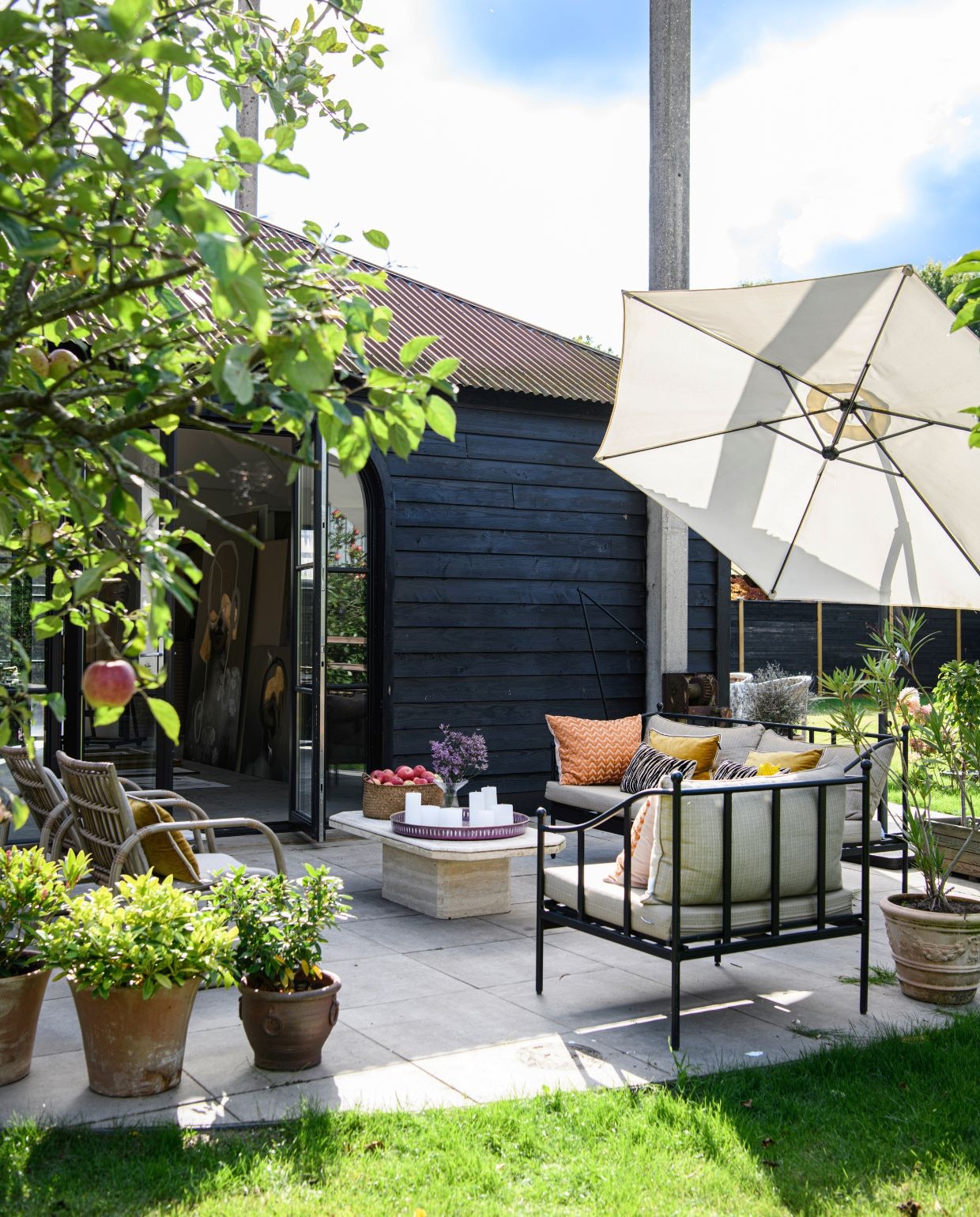 Banken Maisons du Monde. Kussens Élitis. Parasol Sklum. Stoelen Maisons du Monde. Tafel kringloop. Dienblad Van Verre. Mand Intratuin. Potten kringloop en Tuincentrum het Oosten. vtwonen 06-2026 | styling Esther Loonstijn | fotografie Louis Lemaire