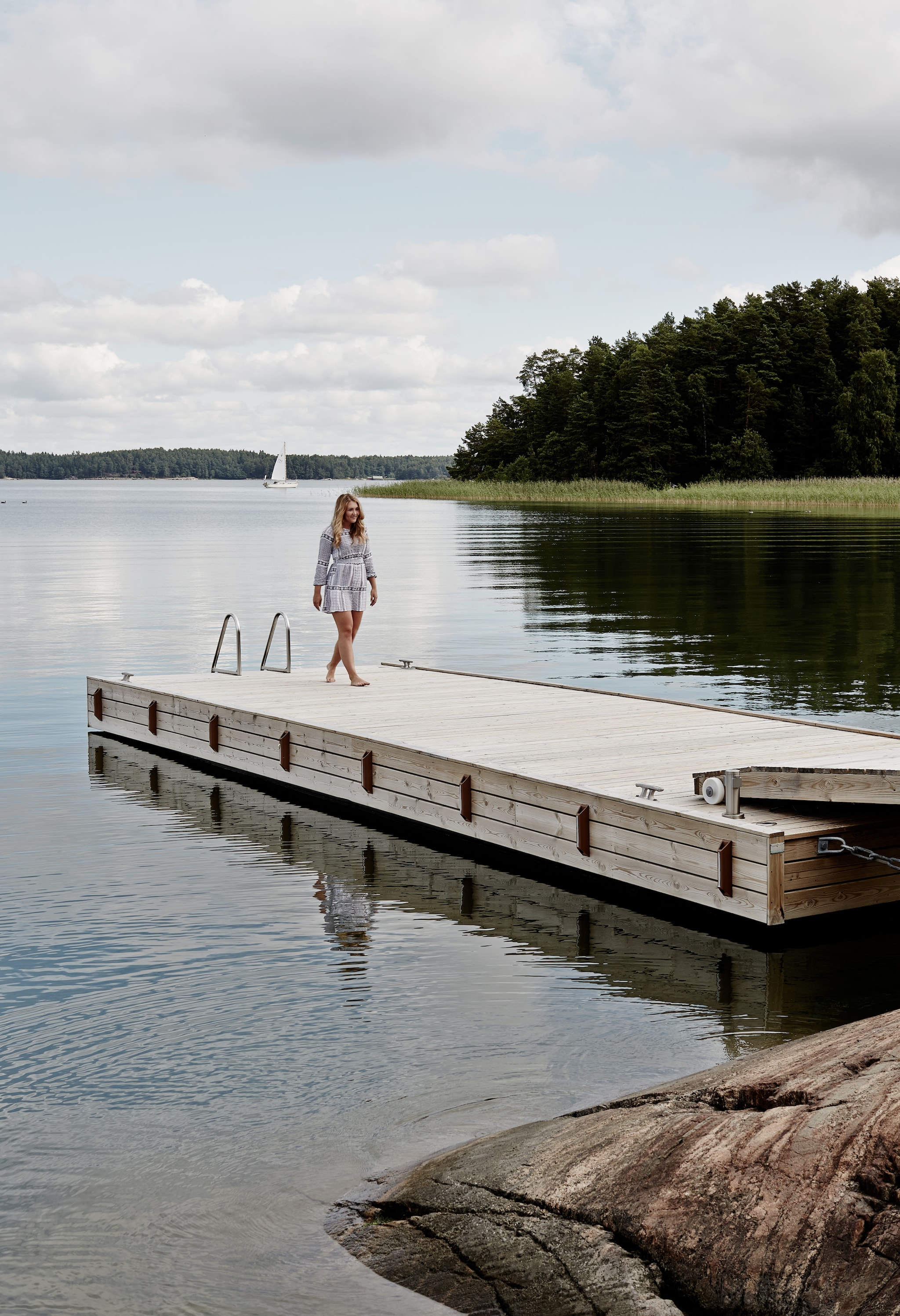 Dochter Saara op de steiger voor het huis. Het kleine eiland beschermt de kust tegen hardere wind. vtwonen Landelijk 08-2026 | fotografie Krista Keltanen | productie Living Inside