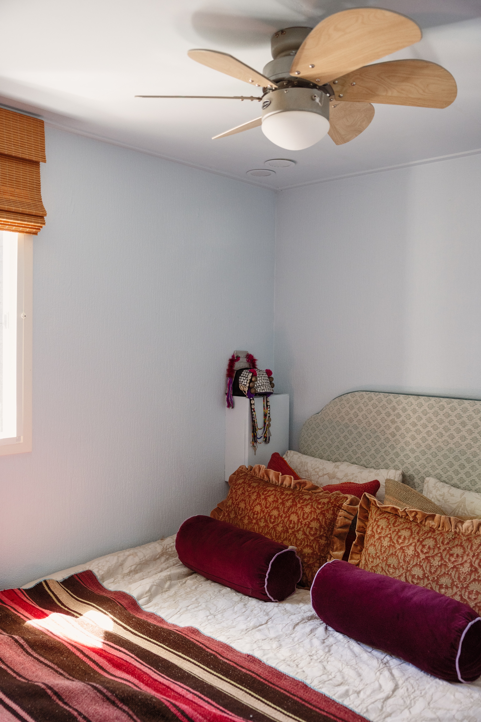 Bed en hoofdbord The Boxspring Club. Deken Van Verre Interior. Kussens en rol-kussens Essenza Home. Ventilator Beliani. Indiaas hoofddeksel vintage. vtwonen 08-2026 | styling Sophie Dirven | fotografie Dana van Leeuwen