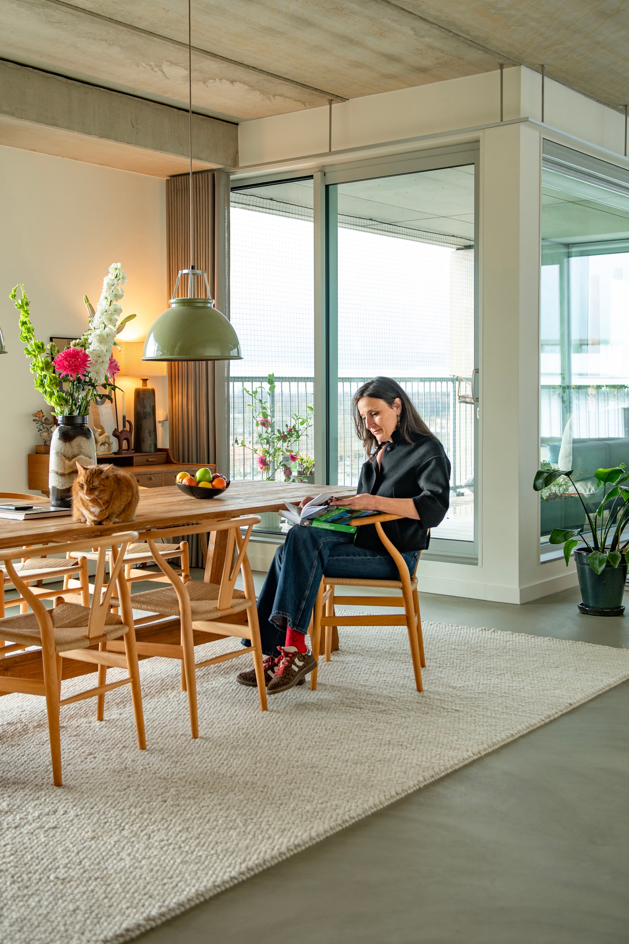 Tafel Loods 5. Stoelen Wishbone van Hans J. Wegner voor Carl Hansen & Søn. Hanglampen Titan van Original Btc. Vloerkleed Trendcarpet. Bureau van Arne Wahl Iversen voor Vinde Møbelfabrik, vintage. Lavasteen gietvloer Berkers Vloeren. vtwonen 09-2026 | fotografie Caroline Coehorst