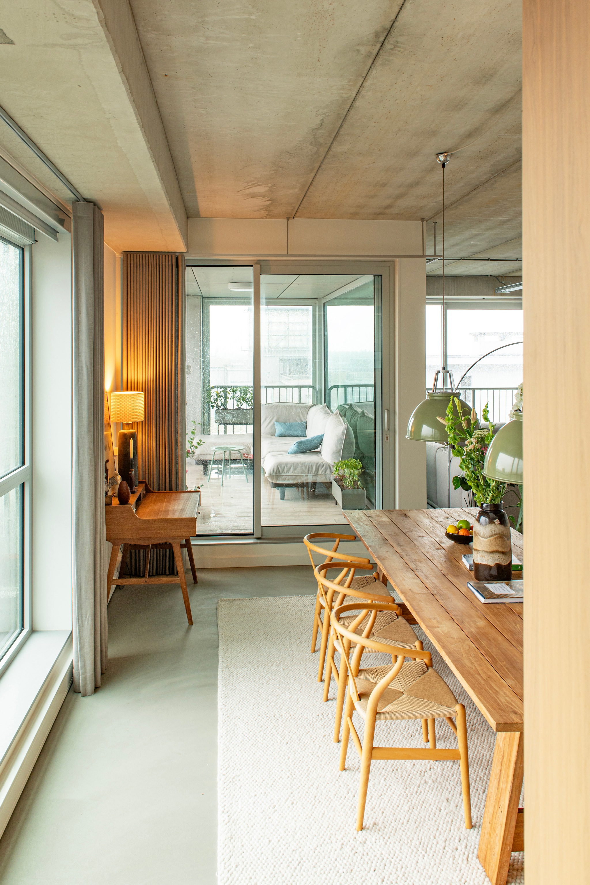 Tafel Loods 5. Stoelen Wishbone van Hans J. Wegner voor Carl Hansen & Søn. Hanglampen Titan van Original Btc. Vloerkleed Trendcarpet. Bureau van Arne Wahl Iversen voor Vinde Møbelfabrik, vintage. Gordijnen Van Eijk Interieur. Buitenbank Fatboy. vtwonen 09-2026 | fotografie Caroline Coehorst