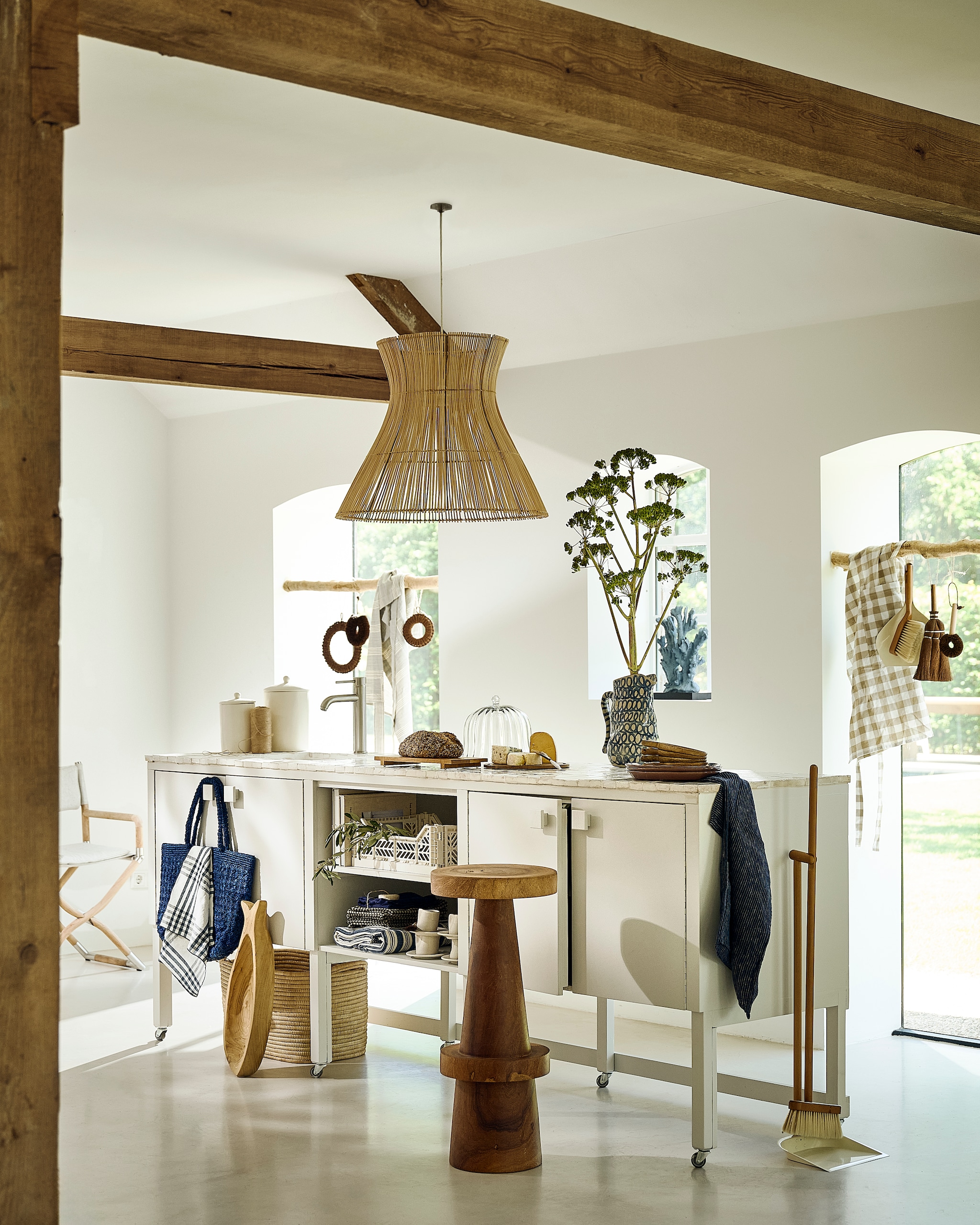 Combitex keuken, op maat gemaakt, hout en tegels, grijs, 251x62x96,5 cm (bxdxh), prijs op aanvraag (com-anders.nl). Designtegels tegel Bejmat Blanc, klei, off white, per m² € 100,- (designtegels.nl). Polspotten kruk, hout, naturel€ 800,- (polspotten.com). Gloster stoel Navigator, hout en stof, naturel-wit € 1870,- (dacks.nl). Household Hardware fruitschaal vis, hout, naturel € 39,-, slabestek vis, hout, naturel € 24,95, espressokop-en-schotel, keramiek, wit € 16,95, theedoek, linnen, zwart-wit € 11,95 (householdhardware.nl). Serax karaf Charly, keramiek, blauw met roomwit € 115,- (serax.com). Couleur Locale mand Malawi, touw, naturel € 99,-, Linge Particulier servet, linnen, atlantic blue € 15,-, Lolo Deco tas Madagascar, raffia, pepita blue € 155,-, Caravane lamp Halo, rotan, naturel € 147,50, Maison de Vacances servet, linnen, blauw-wit € 20,- (couleurlocale.eu). L’Etoile onderzetter klein, bruin € 33,-, onderzetter groot, bruin € 44,-, schrobber, bruin € 22,90, veger, beige € 69,90, schrobber, hout, naturel € 17,90, schort, linnen, blauw-wit € 69,90, kussenhoes, linnen, blauw-wit € 39,90, zeep, prijs op aanvraag, krat, plastic, beige, prijs op aanvraag, dienblad/plank, hout, naturel € 96,- (letoile.store). Zara Home voorraadpot klein, aardewerk, roomwit € 22,99, voorraadpot groot, aardewerk, roomwit € 29,99, stoffer en blik, hout € 17,99, stoffer en blik op voet € 22,99, afdekbaar dienblad/bord, hout en glas € 49,99, gestreepte deken, katoen, blauw-wit € 49,99, geblokt schort, katoen, wit-beige € 17,99, ovaal bord, aardewerk, blauw-wit, per stuk € 22,99 (zarahome.com). Fijnhout buxus B stomp als roede, hout op maat, naturel, per stuk € 19,06 (fijnhout.nl). Maisonnl nepkoraal op voet, blauw € 139,- (maisonnl.com). Overig privébezit. vtwonen landelijk 8-2026 | styling Liza Wassenaar | fotografie Sjoerd Eickmans