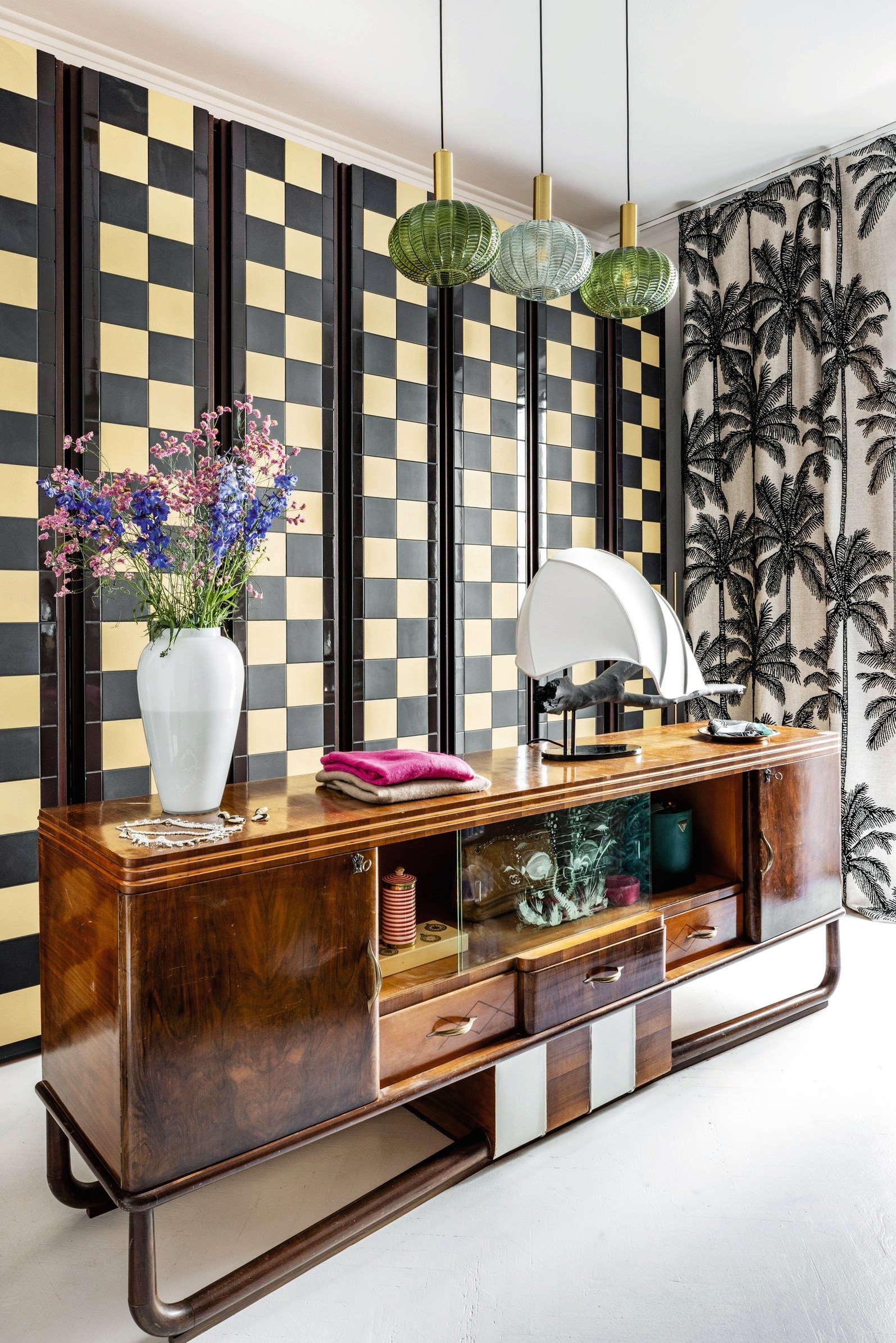 Dressoir, hanglampen en vaas van Muranoglas vintage. Kamerscherm met tegels van Quintessenza Ceramiche gemaakt door Maria Vittoria Paggini. Lamp Corpoluce. Gordijnen met palmbomen Pierre Frey. vtwonen design 5-2026 | fotografie Helenio Barbetta