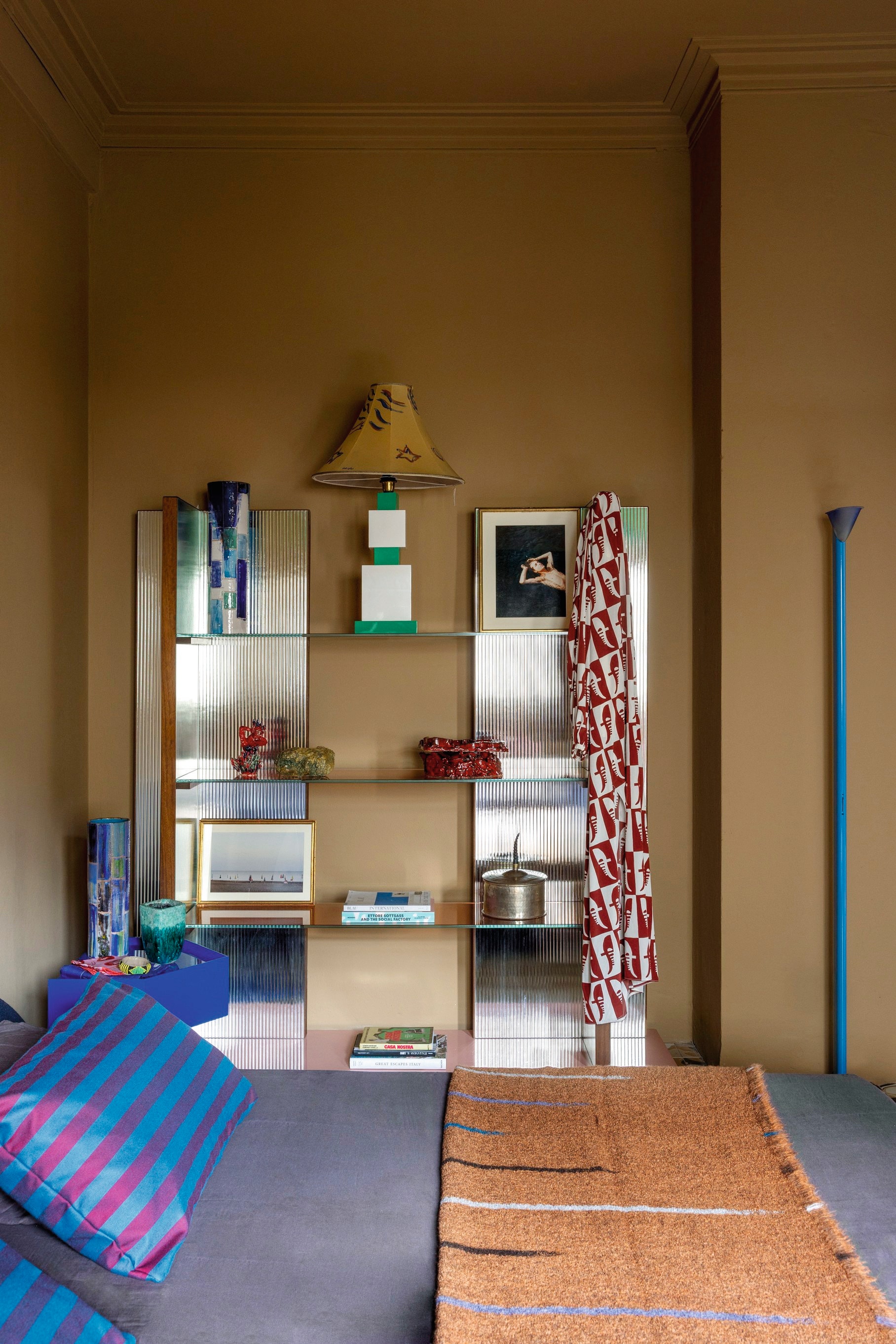 Bed en nachtkastje Maria Vittoria Paggini voor Softhouse. Bedlinnen Society Limonta. Kast Maria Vittoria Paggini. Vazen Giuseppe Palermo. Kaftan Alessandro Gallorini. Fotografie Elena Costa. Schemerlamp Corpoluce. Blauwe staande lamp vintage. Overige objecten vintage. vtwonen design 5-2026 | fotografie Helenio Barbetta