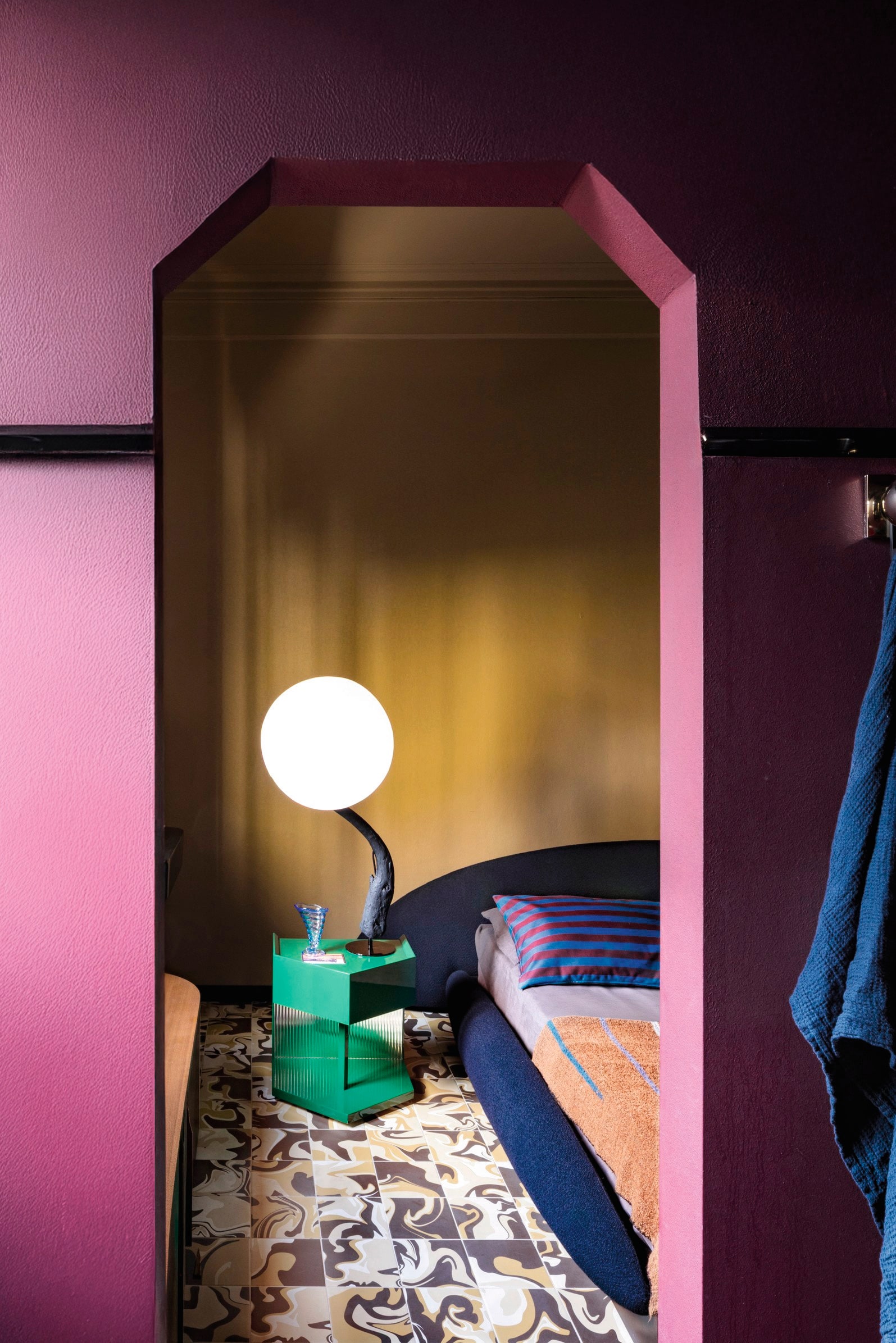 Bed en groene bijzettafel Maria Vittoria Paggini voor Softhouse. Bedlinnen Society Limonta. Tegelvloer Quintessenza Ceramiche. Lamp Corpoluce. Vaas vintage. vtwonen design 5-2026 | fotografie Helenio Barbetta