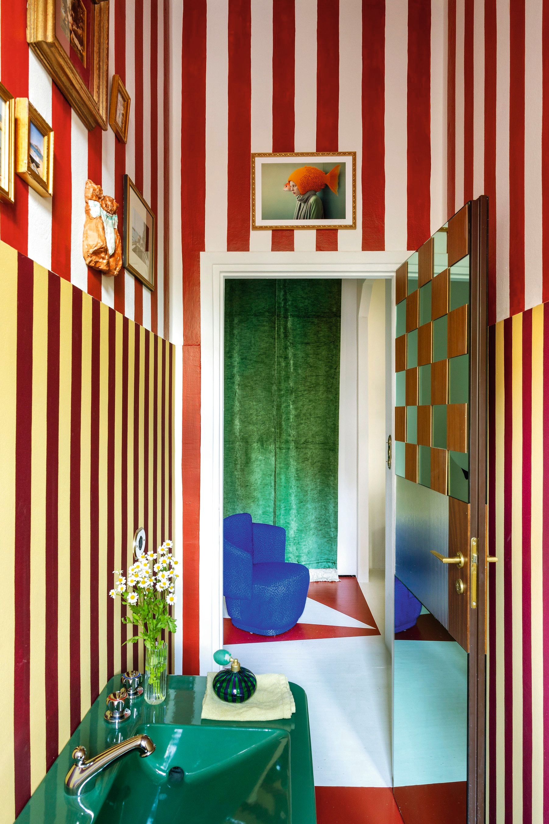 Groene wastafel en kraan Mamoli. Behang, muurverf en vloer Gouache. Blauwe fauteuil Softhouse Design. Kunstwerk met goudvis Ludovica Lugli. Kunst links Tatiana Brodatch en Alberto Alicata. vtwonen design 5-2026 | fotografie Helenio Barbetta