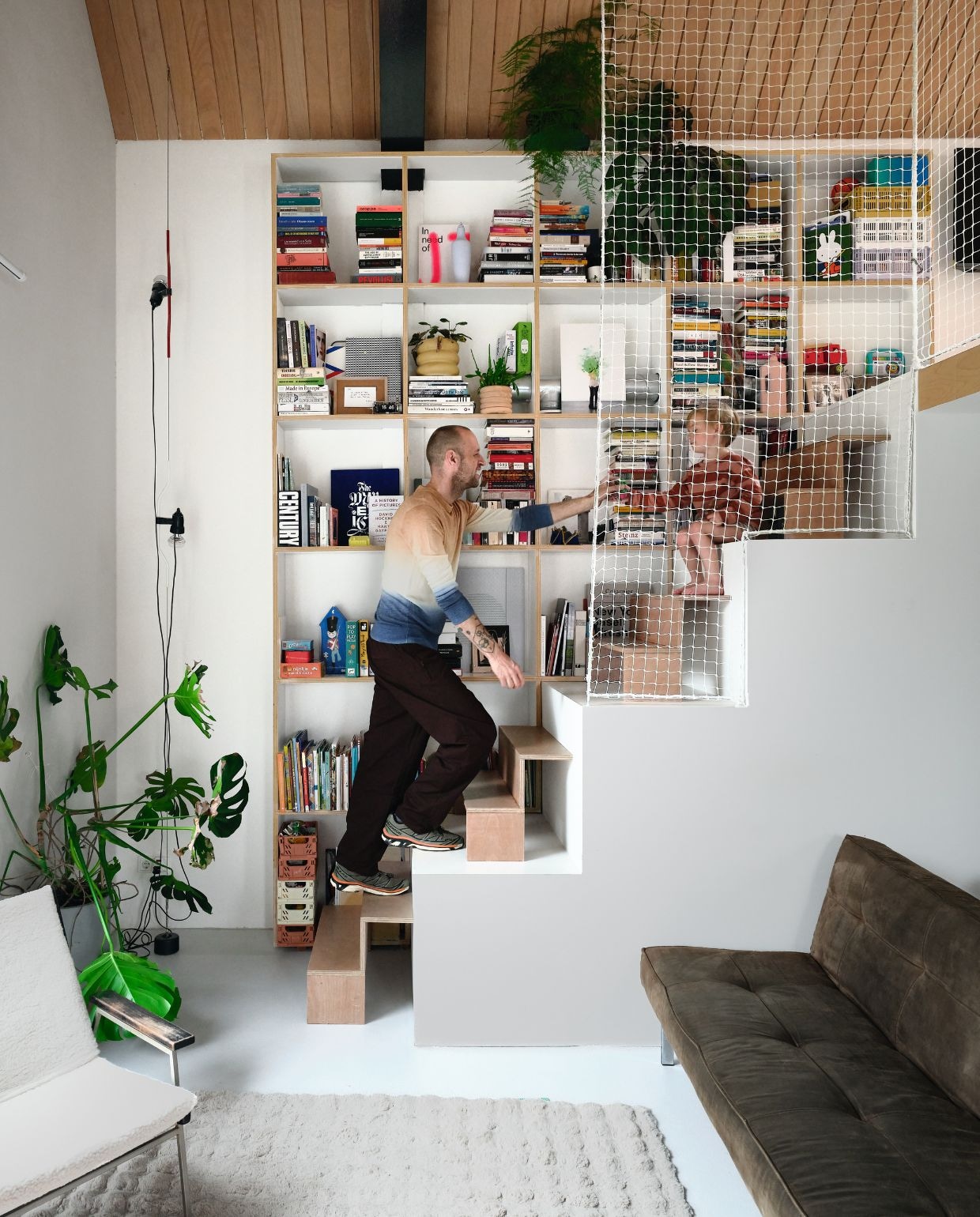 Stoel straatvondst, herbekleed met wol. Lampen Parentesi van Flos. Boekenkast en trap, eigen ontwerp van Dirk. In de kast: kunst van Steven van Lummel, kaars van het Stroomhuis. vtwonen 06-2026 | fotografie Mr. Frank