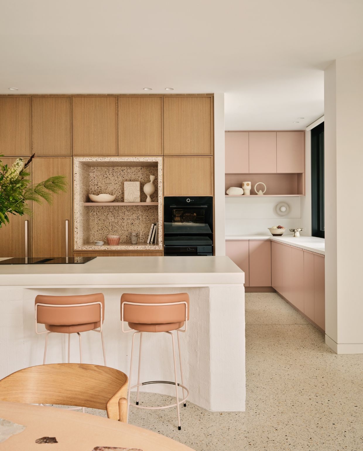 Keuken met kastfronten in de kleur Earthwarming van Dulux. Oven Ilve. Niswand van terrazzo. Vloer Mentone Premix en Snowstone 32 Std White. Fruitschaal Lola Terracotta Salad Bowl van Jardan. Vaas Krosno. vtwonen Design 05-2026 | fotografie Lisa Cohen