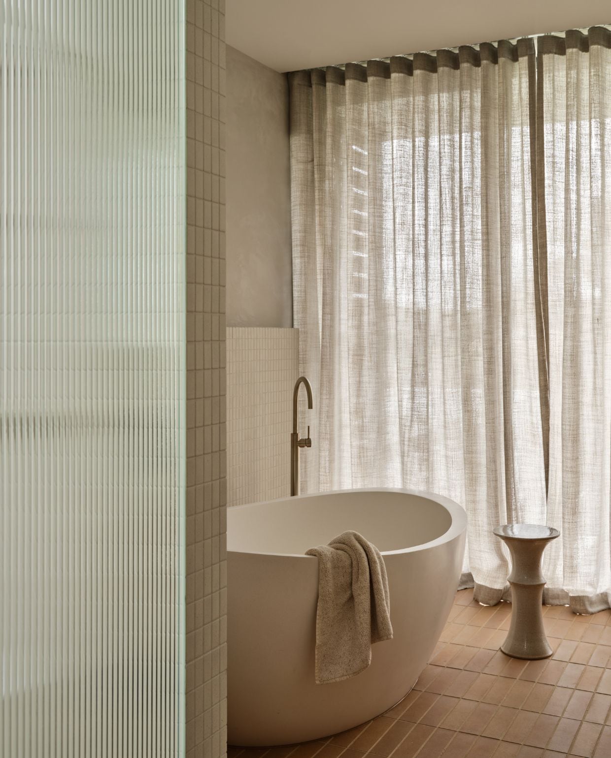 Ligbad Oman in Diamond White van Apaiser. Tegels Artedomus. Handdoek Country Road. Kraanwerk Faucet Strommen. Bijzettafel Plinth van Alison Frith. vtwonen Design 05-2026 | fotografie Lisa Cohen