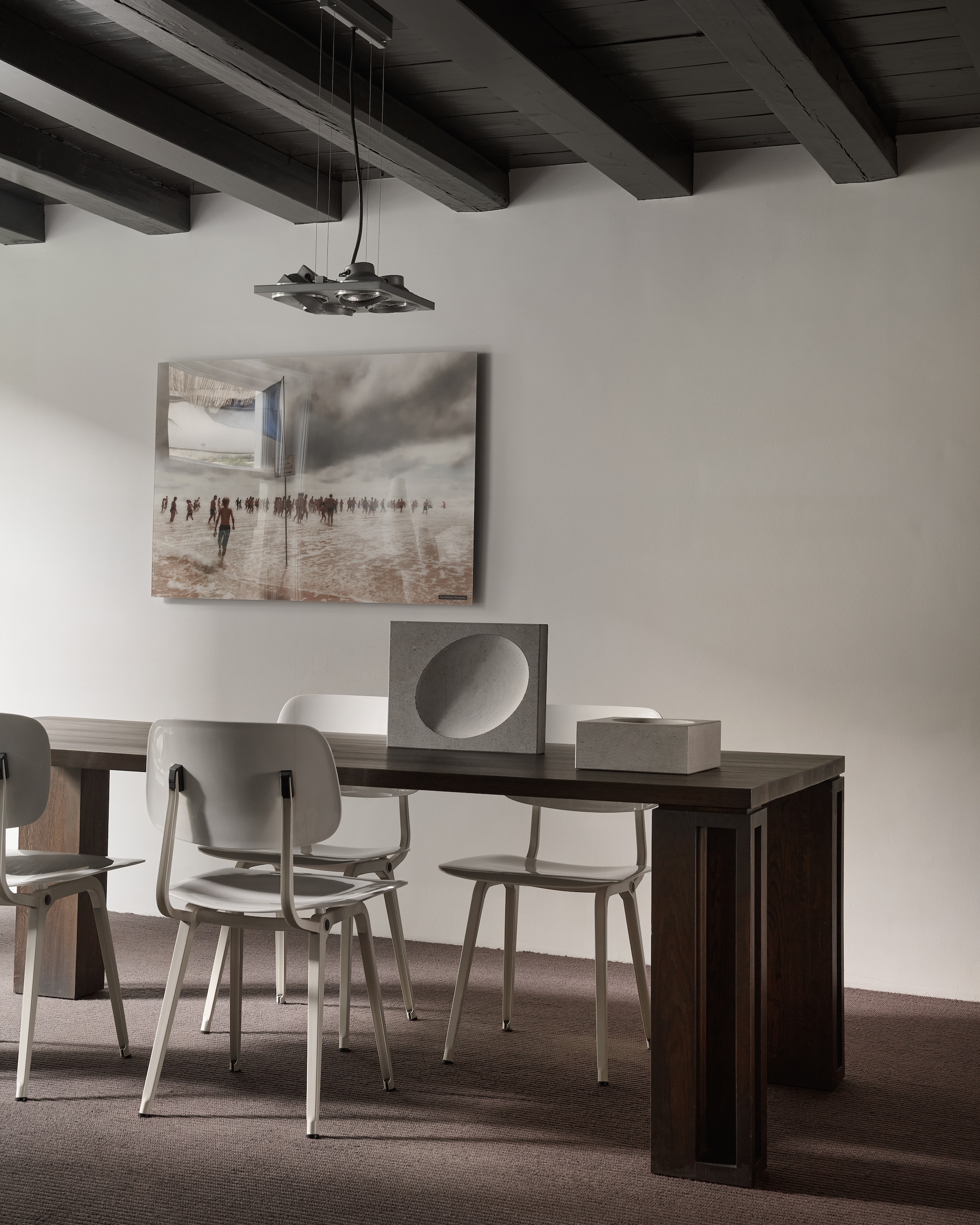 De vergaderruimte in de studio. Houten tafel en objecten gemaakt van grijs basaltsteen, ontworpen door Remy Meijers.  Stoelen van Friso Kramer voor Ahrend. Verlichting Modular Lighting Instruments. vtwonen design 7-2026 | fotografie Kasia Gatkowska
