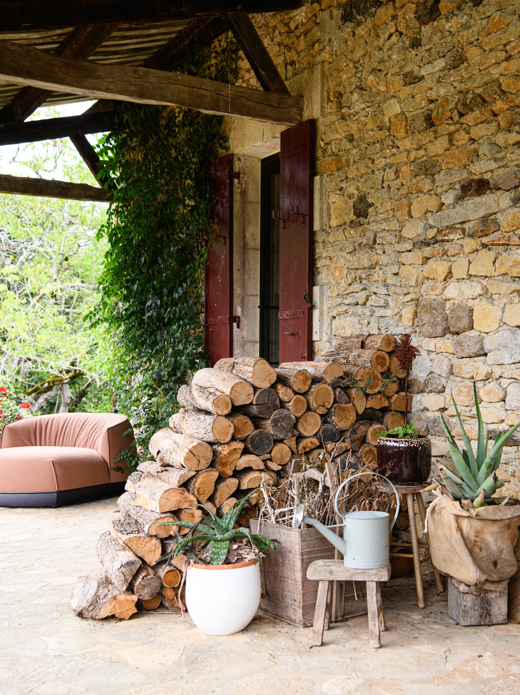 Tuinfauteuil Brioni van Kristalia. Plantenpotten, 
gieter, krat en krukken zijn lokale vondsten. vtwonen Landelijk 09-2026 | styling Inge van Lieshout | fotografie Louis Lemaire | productie Insidehomepage