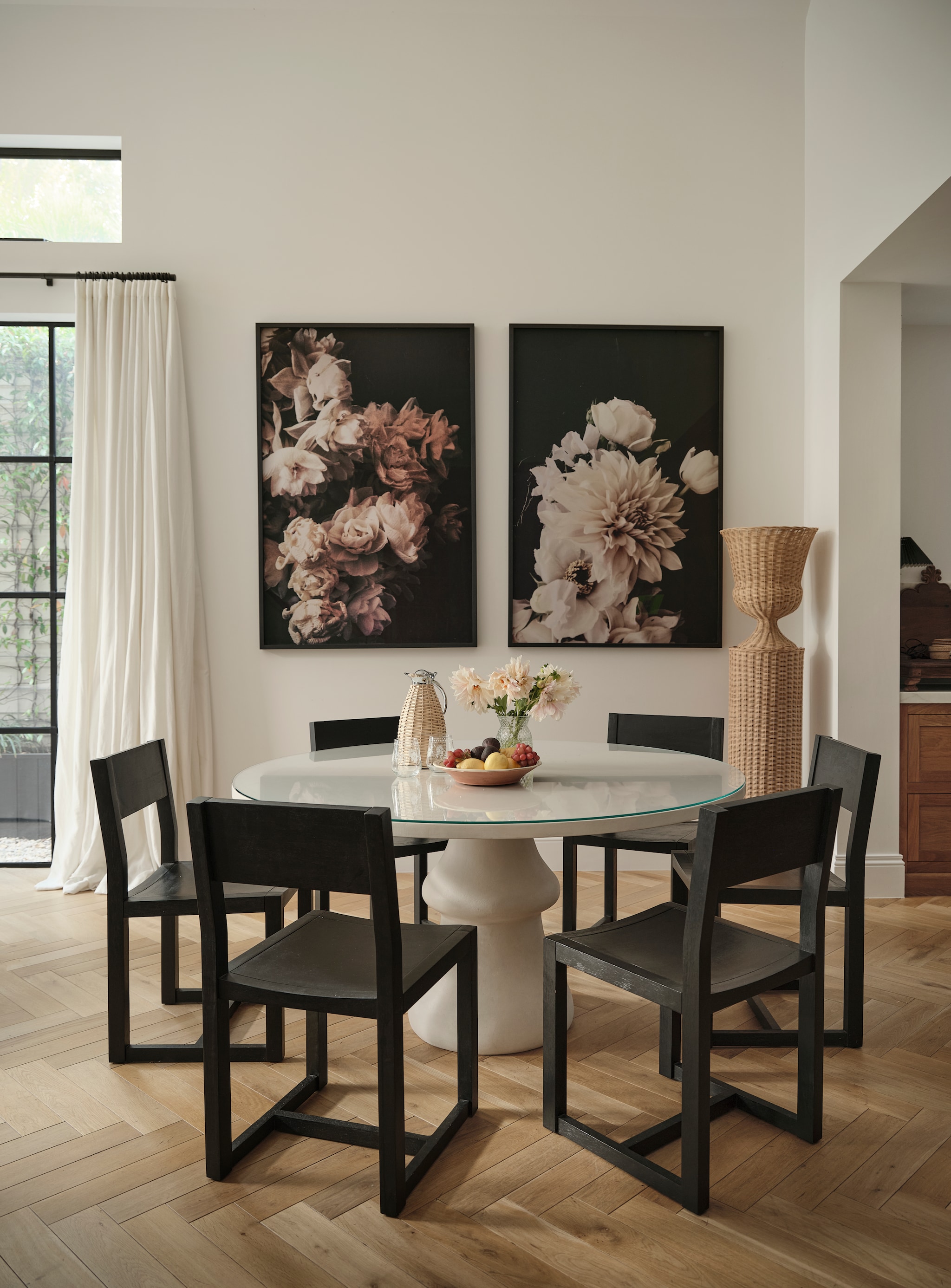 Tafel van gips en glas, maatwerk naar ontwerp van Susan. Ingelijste bloemenfoto’s Ashley Woodson Bailey. Rieten zuil Medici van Atelier Vime Editions. Vergelijkbare eetkamer-stoelen Pottery Barn. Vergelijkbare rieten waterkan Uru Home. Linnen gordijnen Linesta Pearl van Warwick. vtwonen Landelijk 9-2026 | fotografie Lisa Cohen