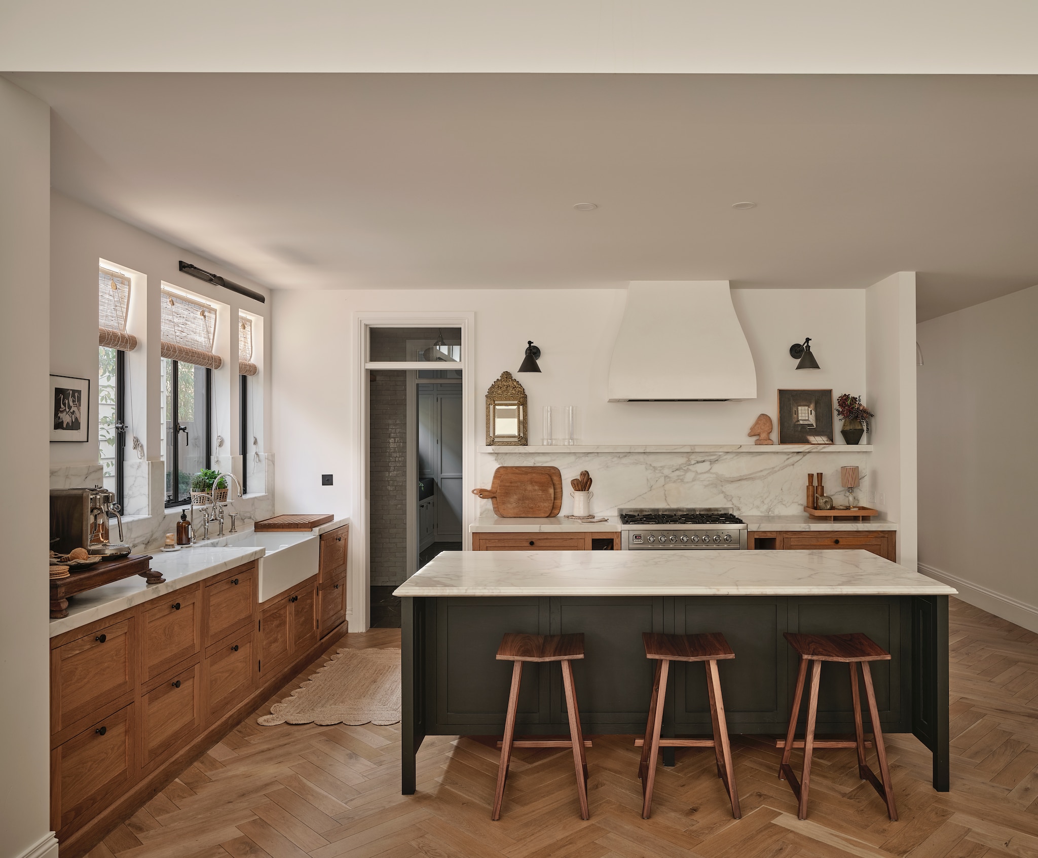 Keuken op maat gemaakt van eiken en marmer, naar eigen ontwerp. Schouw om afzuigkap op maat gemaakt van gips. Dubbele butlerspoelbak van vuurklei Acquello en kranen van English Tapware. Antieke Indiase lage tafel op aanrecht Few & Far. Walnoten krukken Woodford van Mr and Mrs White. Bibliotheeklampen Boston van The Montauk Lighting Company. Vergelijkbaar juten vloerkleed met geschulpte rand Tate & Darby. Eikenhouten snijplanken Berdoulat. Verf keukeneiland Black Cockatoo van Porter’s Paint. Kunstwerken en decoratieve voorwerpen vintage. vtwonen Landelijk 9-2026 | fotografie Lisa Cohen