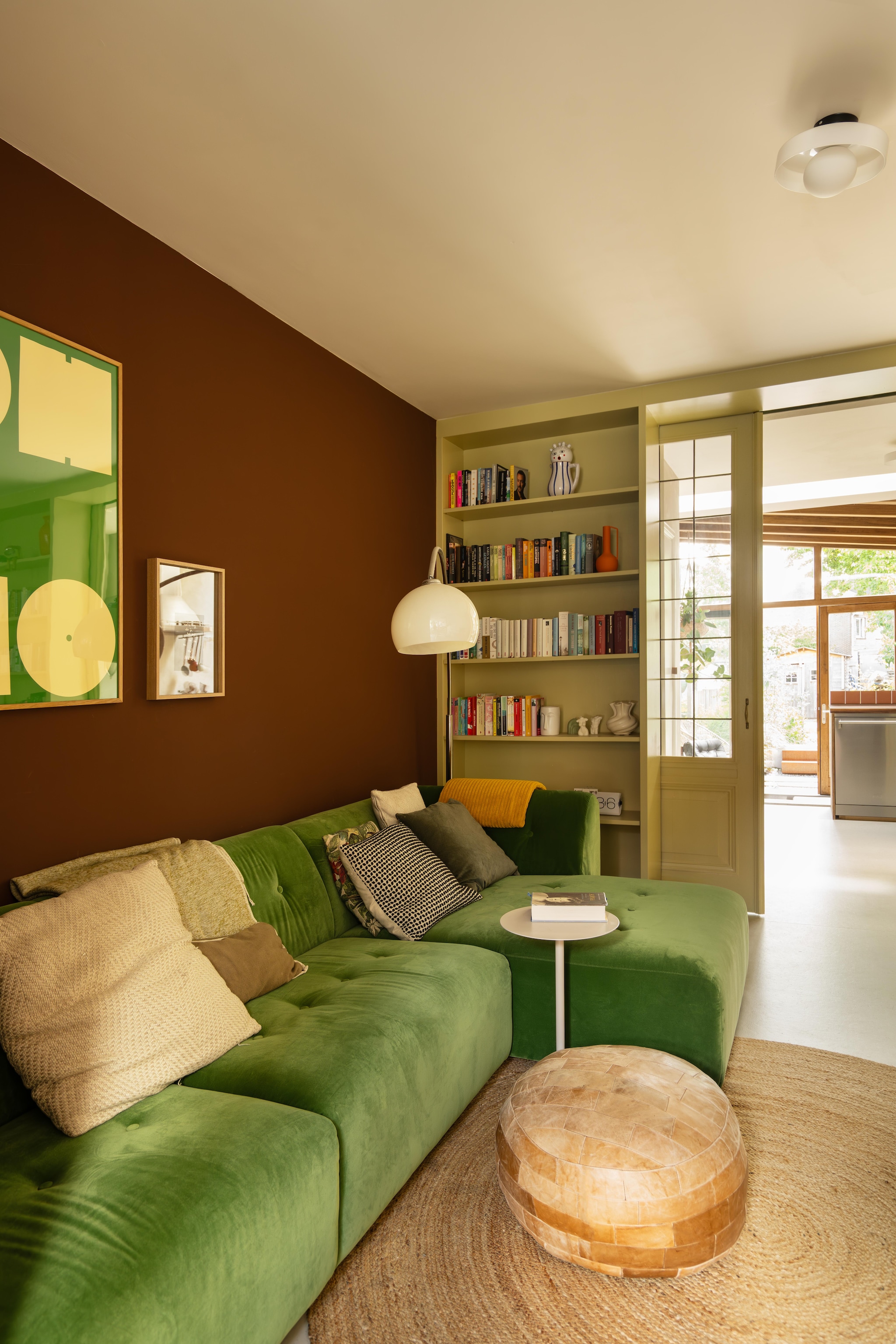 Op de muur marble paint kleur Coffee van St. Leo. Vintage meubels Marktplaats en kringloop Poef Vint Amersfoort. En-suitedeuren uit een oud Rotterdams slooppand. Bijzettafel, kleed Kwantum. Posters Wallofart designed by K-w. Booglamp Marktplaats. vtwonen 09-2026 | fotografie Lotte van Uittert