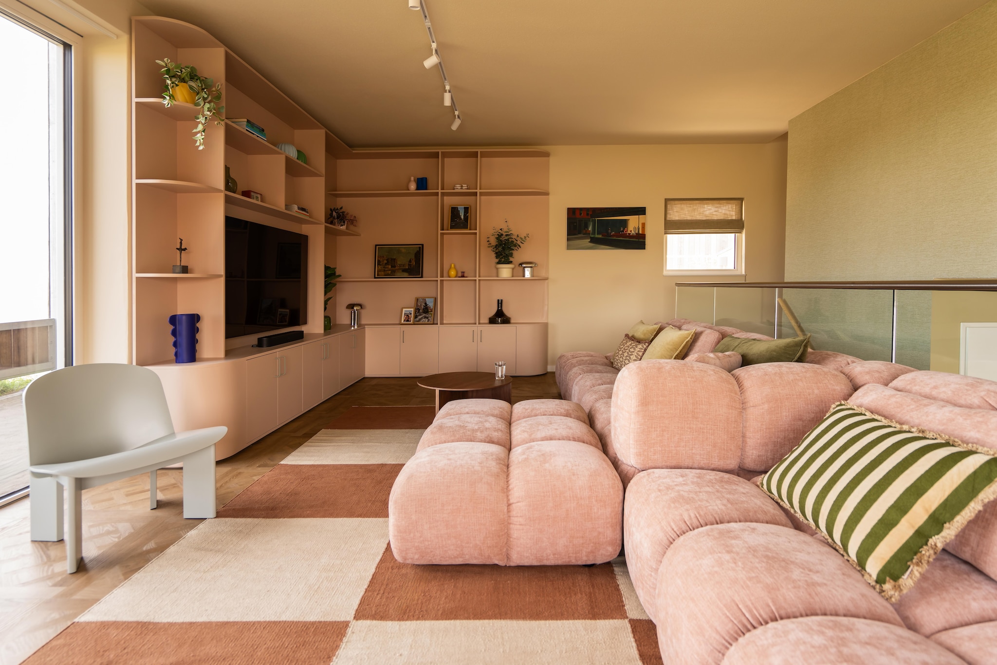 Bank Nous Living. Kussens Loods 5, H&M Home en Kwantum. Dryback pvc-vloer Royal sun kissed van vtwonen voor Floorlife. Vloerkleed H&M Home. Stoel Chisel Eucalyptus van Hay. Maatwerkkast Tim Vinke, geverfd in Templeton Pink van Farrow & Ball. Bijzettafel Slit van Hay. Muurkleur Joa’s White van Farrow & Ball. Vinylbehang Luxor in 1123.08 van Vescom. Kunstwerk Nighthawks van Edward Hopper via Werk aan de Muur. Blauwe, gele en witte vazen Ikea. Chromen lampen Søstrene Grene. Vouwgordijn Nova Linnen vnovg04 van Veneta. vtwonen 09-2026 | fotografie Lotte van Uittert