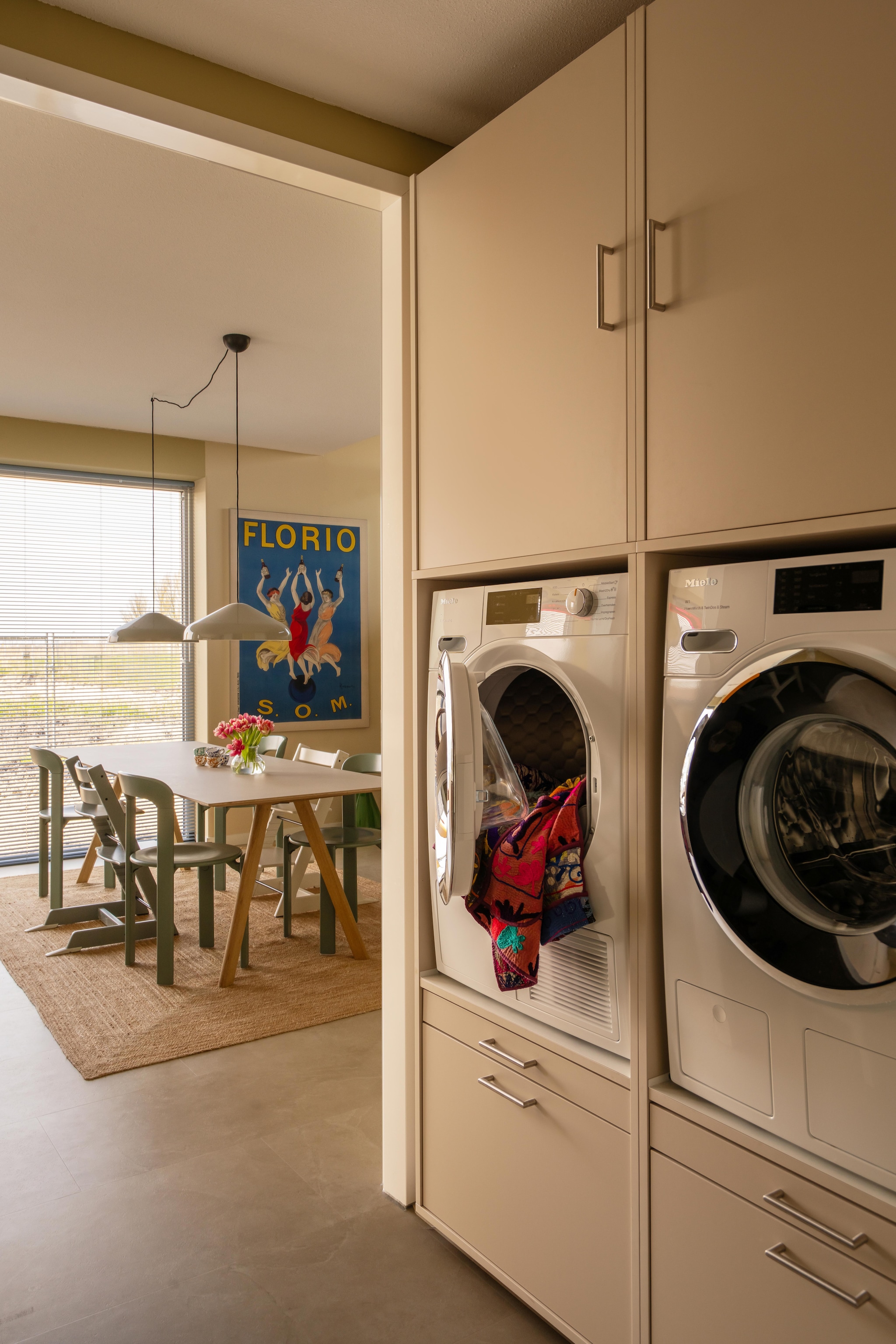 Wasmachinekast Wastoren. Kunstwerk Florio van Leonetto Cappiello via Werk aan de Muur. Vloer Stanmore dryback beige van Floorlife. Vloerkleed Zara Home. vtwonen 09-2026 | fotografie Lotte van Uittert