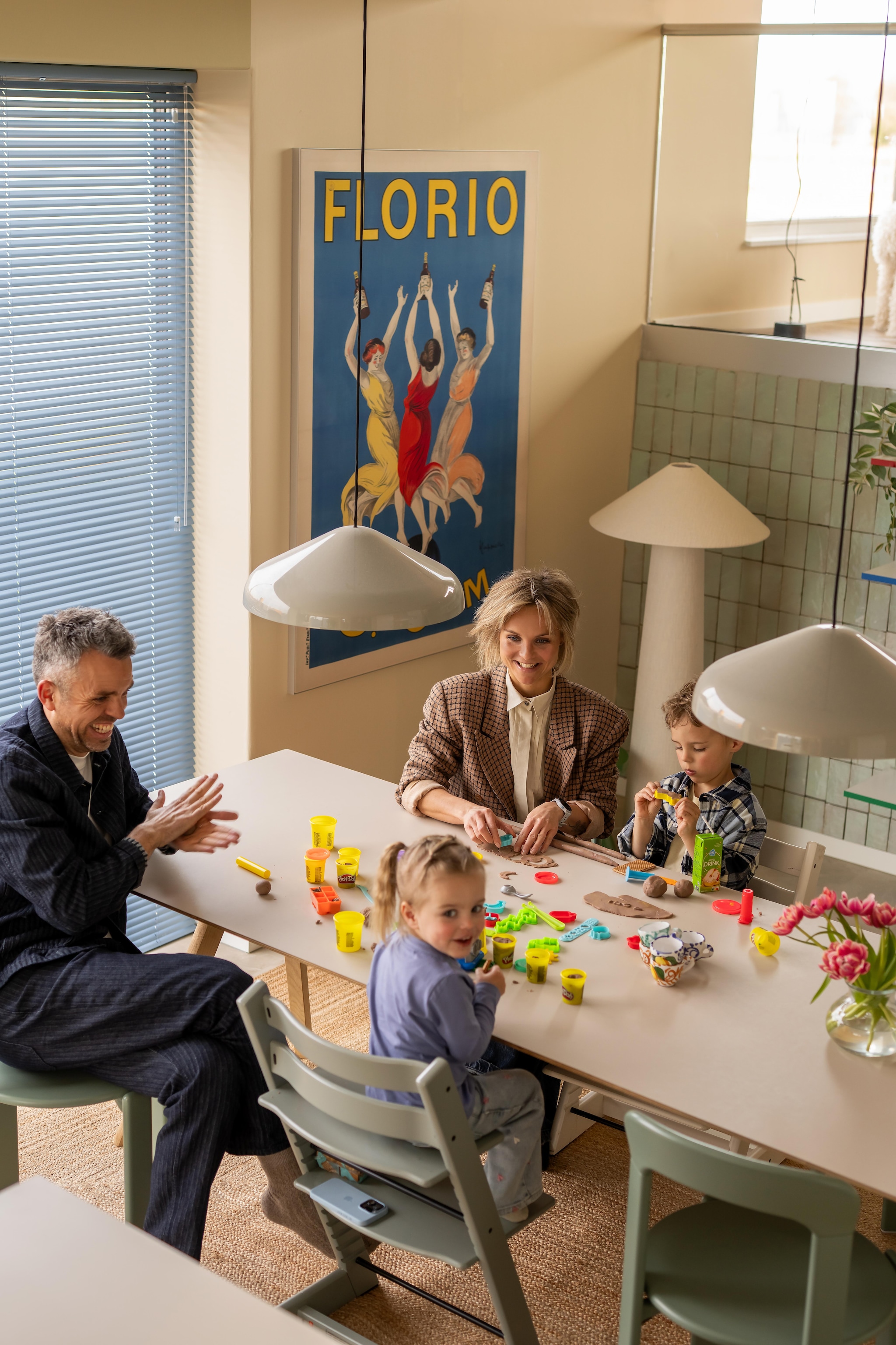 Tafel, stoelen en hanglampen Hay. Kinderstoelen Tripp Trapp van Stokke. Vloerkleed Zara Home. Kunstwerk Florio van Leonetto Cappiello via Werk aan de Muur. Stalamp Kwantum. Tegels Platta Vert Clair via Designtegels. Aluminium jaloezieën Allure in Baby Blue van Veneta. vtwonen 09-2026 | fotografie Lotte van Uittert