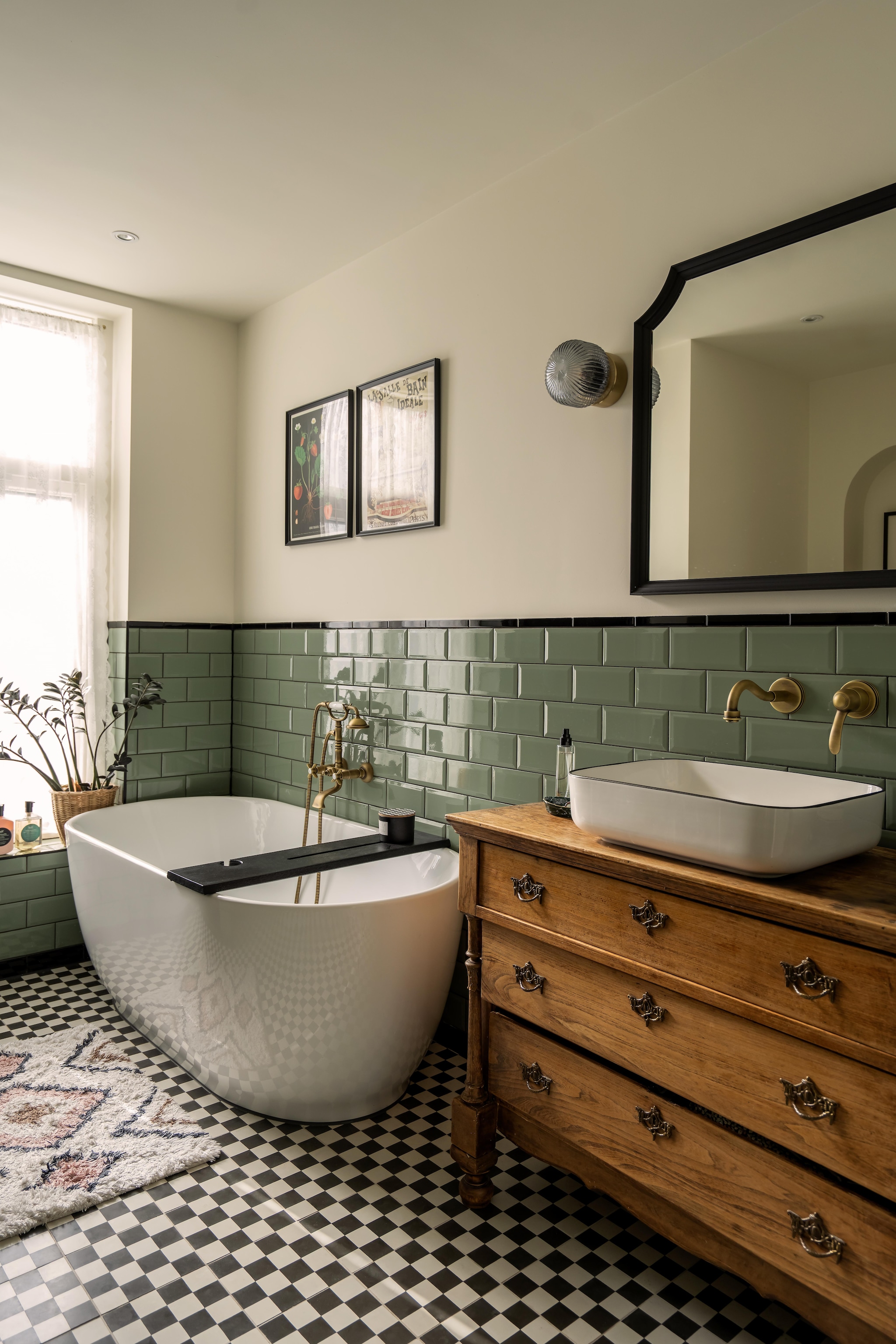 Messing kranen Tres Clasic. Tegels metro kleur jade groen van Tegels in Huis. Wandlampen Solklint en spiegel Ikea. Tweedehands ladekast. Vloer Blocks S800 van Designtegels. Bad Sanituba Miami en waskom Saniclear Blitz van Sanitairkamer. Badmat H&m Home. vtwonen 09-2026 | fotografie Lotte van Uittert
