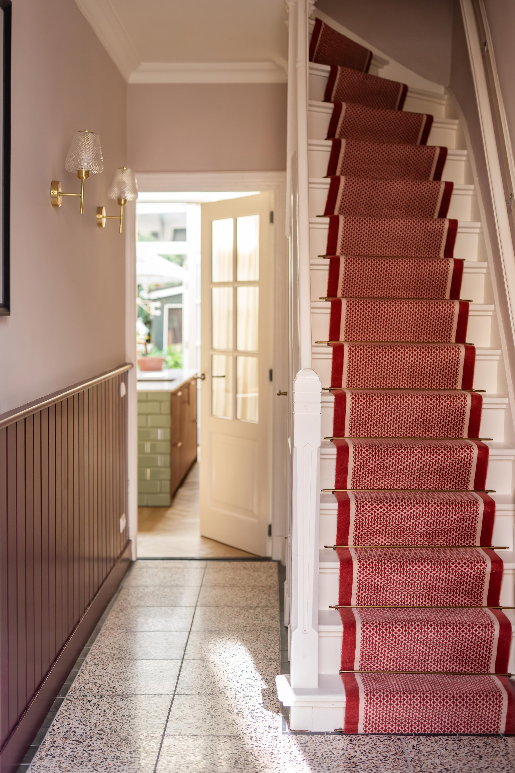 Tegels Terrazzo Di Caffe van Designtegels. Wandlampen Taylor van Sklum. Traploper De Roode Loper. Verfkleur wand Zorgvuldig van Gamma. Verfkleur lambrisering Brinjal van Farrow & Ball. vtwonen 09-2026 | fotografie Lotte van Uittert