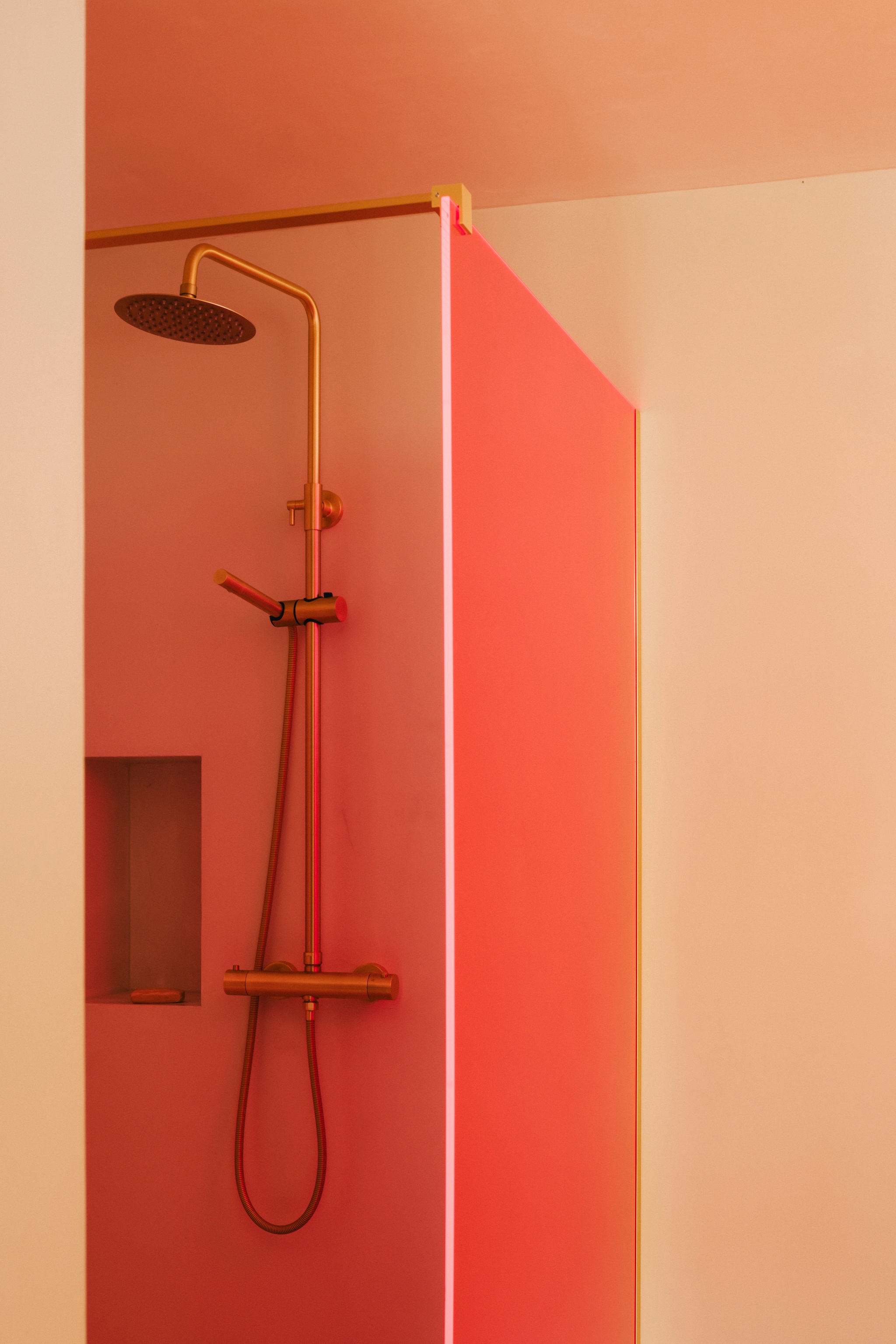 De roze douchewand verspreidt een vrolijke gloed door de badkamer. vtwonen design 7-2026 | fotografie Katoo Peeters
