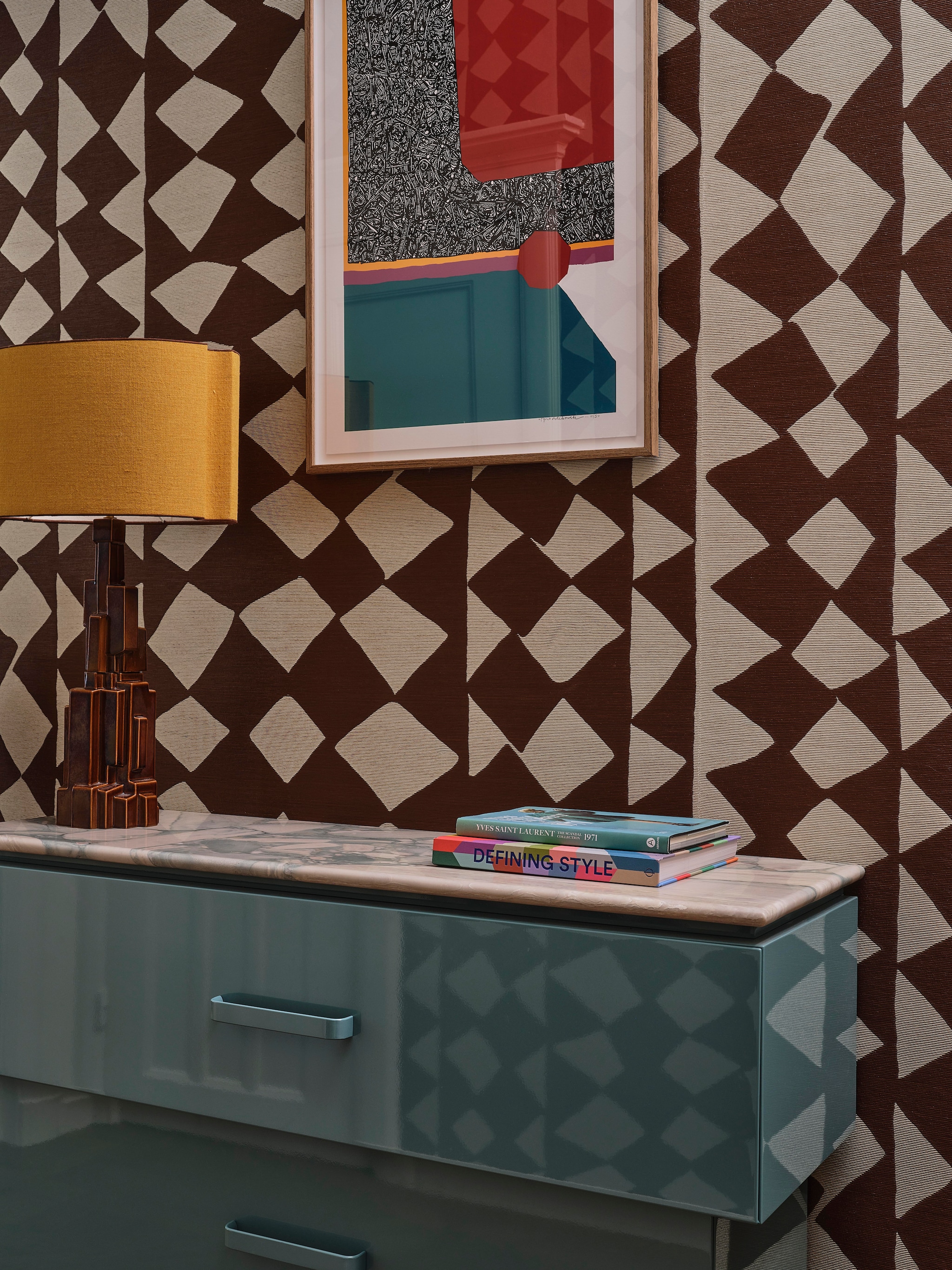 Behang Efutu Cacao van Pierre Frey. Spiegel en poef ingebracht door bewoners. Ladekast ontworpen door Atelier ND Interior, gemaakt door Job Interieurbouw en gespoten in hoogglanskleur Jericho Jade 1142-6. Marmeren blad Jan Reek Natuursteen. Vintage lamp René Houben Decorum. Afrikaans kunstwerk (zeefdruk) rechterwand Summer Camp van Tyna Adebowale via Atelier ND Interior. Kunstwerk achterwand Billy und Hells, via Morren Gallery. vtwonen design 8-2026 | fotografie Space Content Studio