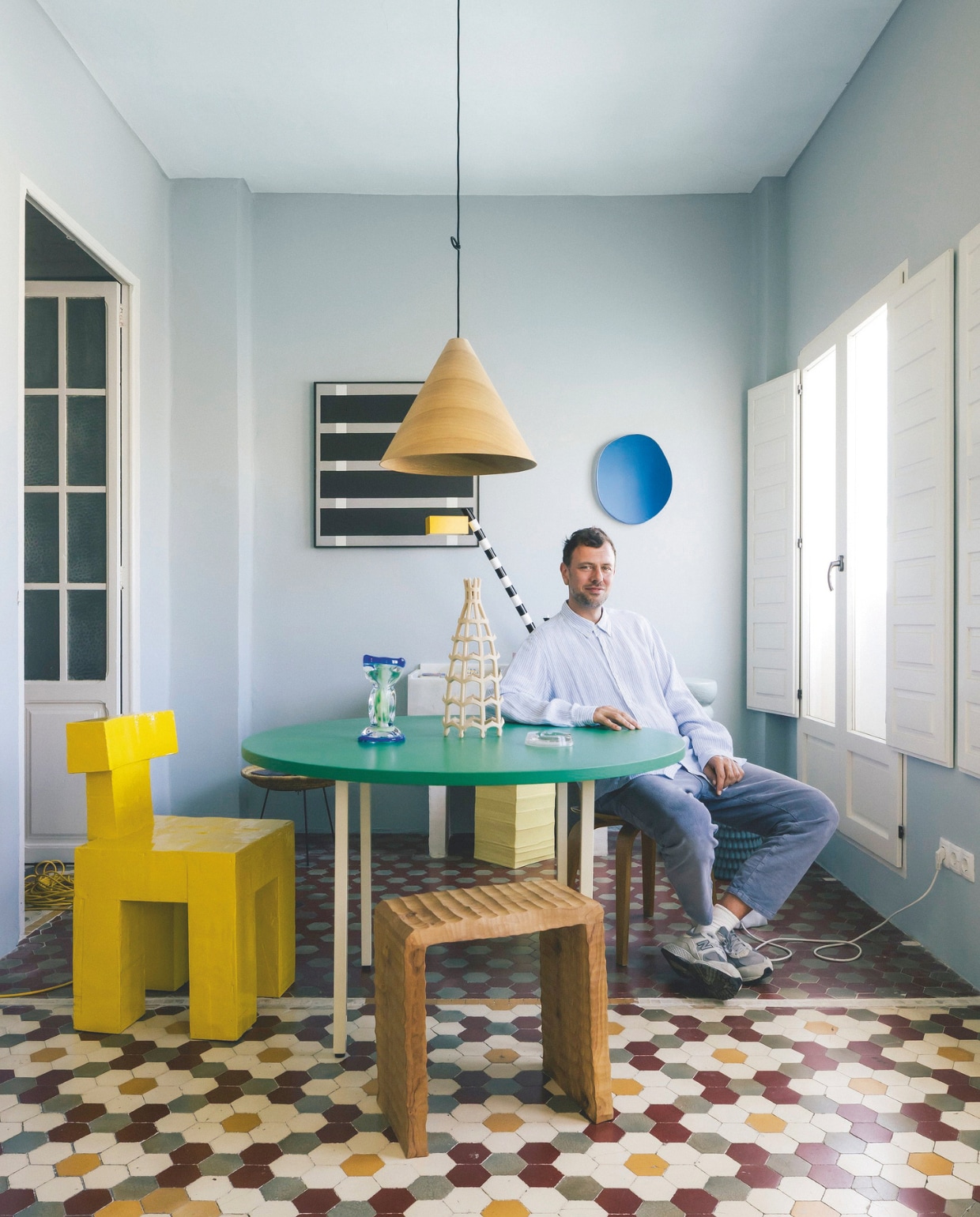 Gele stoel Practice Chair van Studio Fabius Clovis. Tafel Two-colour van Hay. Kruk Beaver Dreams van Kasper Boelens. Lamp 30 Degrees van Hay. Wandkunst via Oode. Spiegel Off round van Sabine Marcelis en Brit van Nerven. Lamp Oceanic van Ettore Sottsass voor Memphis Milano. Op tafel: The Ocean Cup van Sandra Planken Noun. Kandelaar Gravity van Atelier Fig. Asbak matglas ss Normandie French Line. vtwonen design 6-2026 | fotografie Katoo Peeters