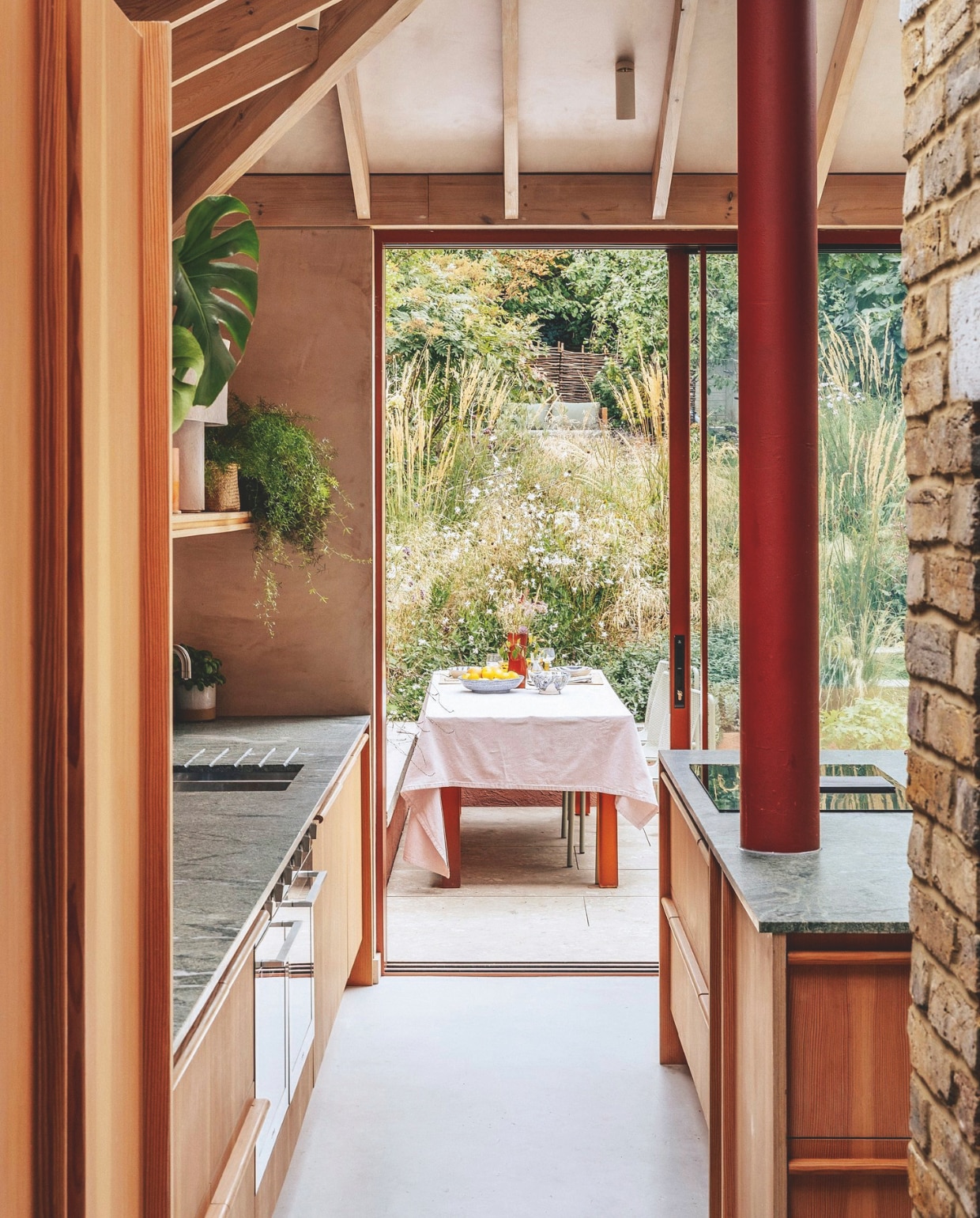 Keukenontwerp Bechtolsheim Studio, uitgevoerd in berken multiplex en afgewerkt met Douglas-fineer. Fruitschaal Caroline Owen. Buitentegels Cosmo Sand van Sant’Agostino. Rode vaas Sola van Ferm Living. vtwonen 07-2026 | fotografie Taran Wilkhu