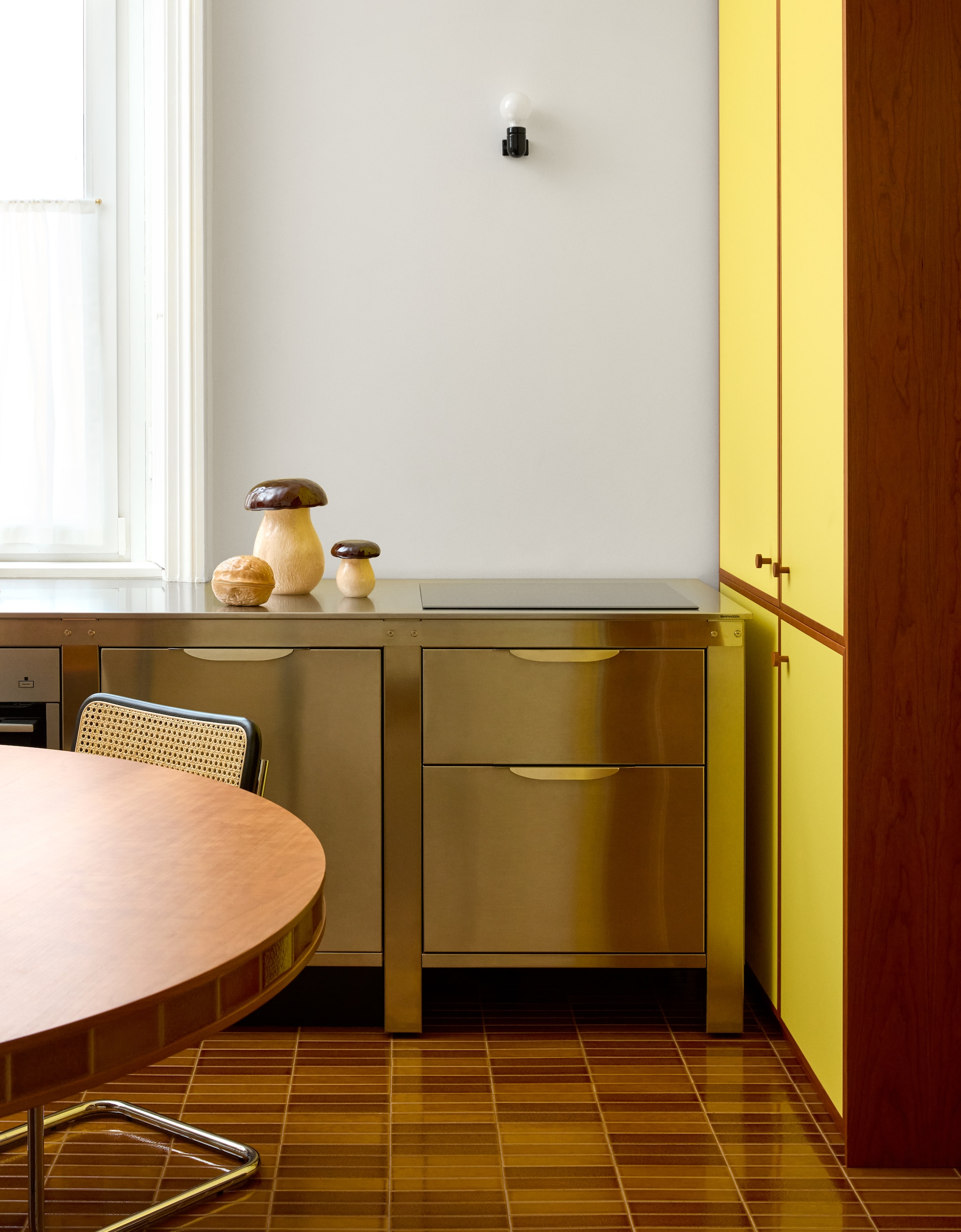 Tafel en vloer met tegels van vulkanische as Formafantasma voor Dzek. Stalen buisstoelen Marcel Breuer. Hanglamp Isamu Noguchi. Schilderij Orazio Orazi. Zwart potje Enzo Mari. Roestvrijstalen keuken Very Simple Kitchen. vtwonen design 8-2026 | fotografie Chiara Quadri