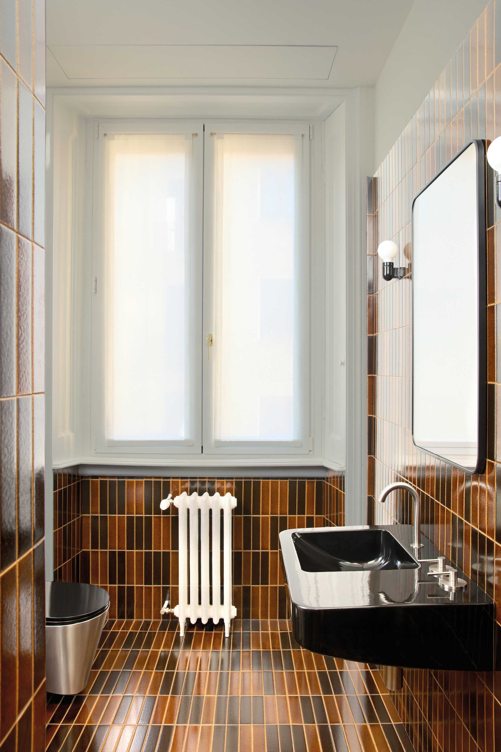 Tegels van vulkanische as Formafantasma voor Dzek. Wastafel Gio Ponti. Kraan Formafantasma voor Quadro Design. Spiegel en wandlamp vintage. vtwonen design 8-2026 | fotografie Chiara Quadri