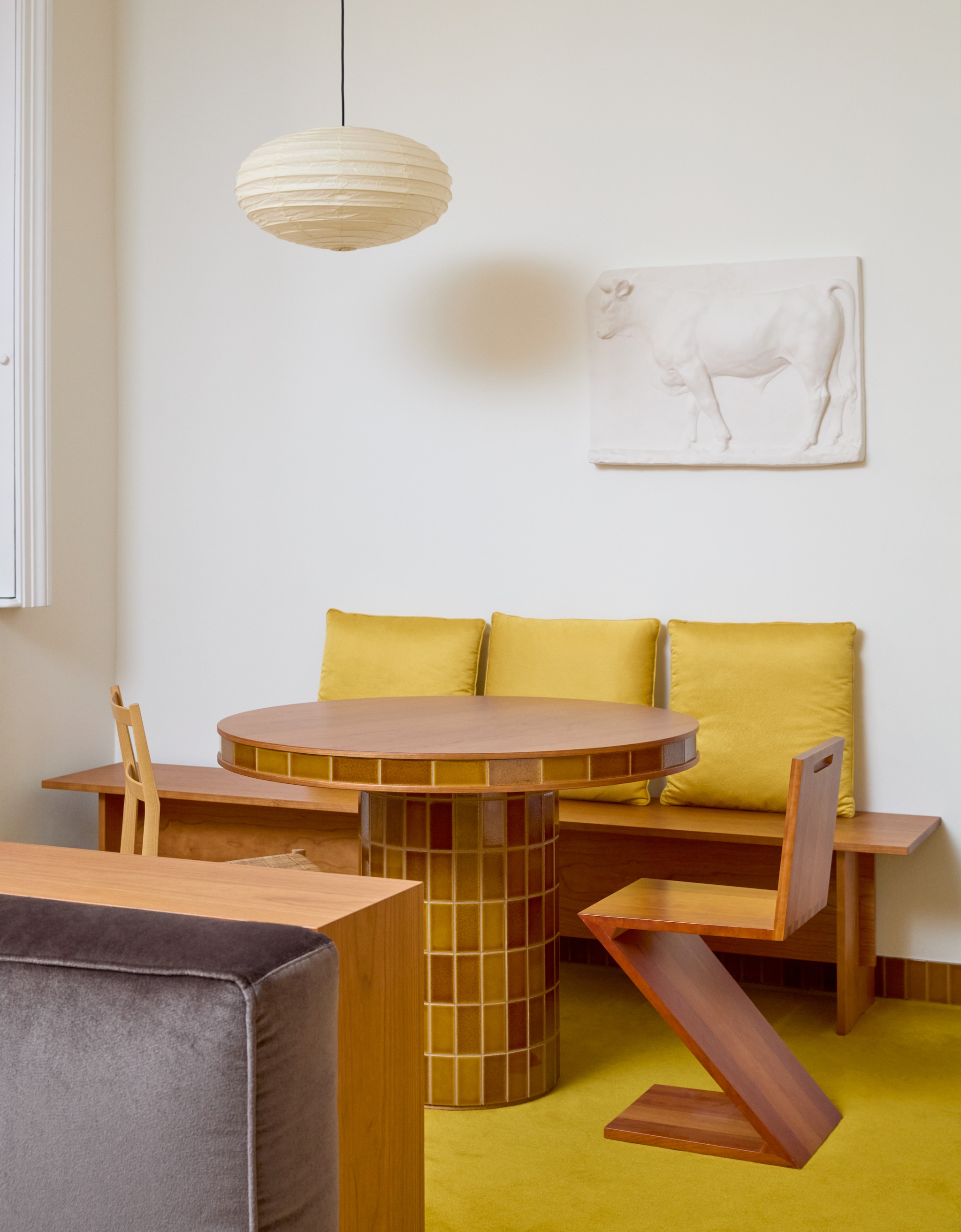 Kersenhouten bank met gele kussens Formafantasma. Tafel Formafantasma voor Dzek. Zigzag-stoel van Gerrit Rietveld voor Cassina. Houten stoel Superleggera van Giò Ponti voor Cassina. Kunstwerk van pleister Fumagalli & Dossi. vtwonen design 8-2026 | fotografie Chiara Quadri