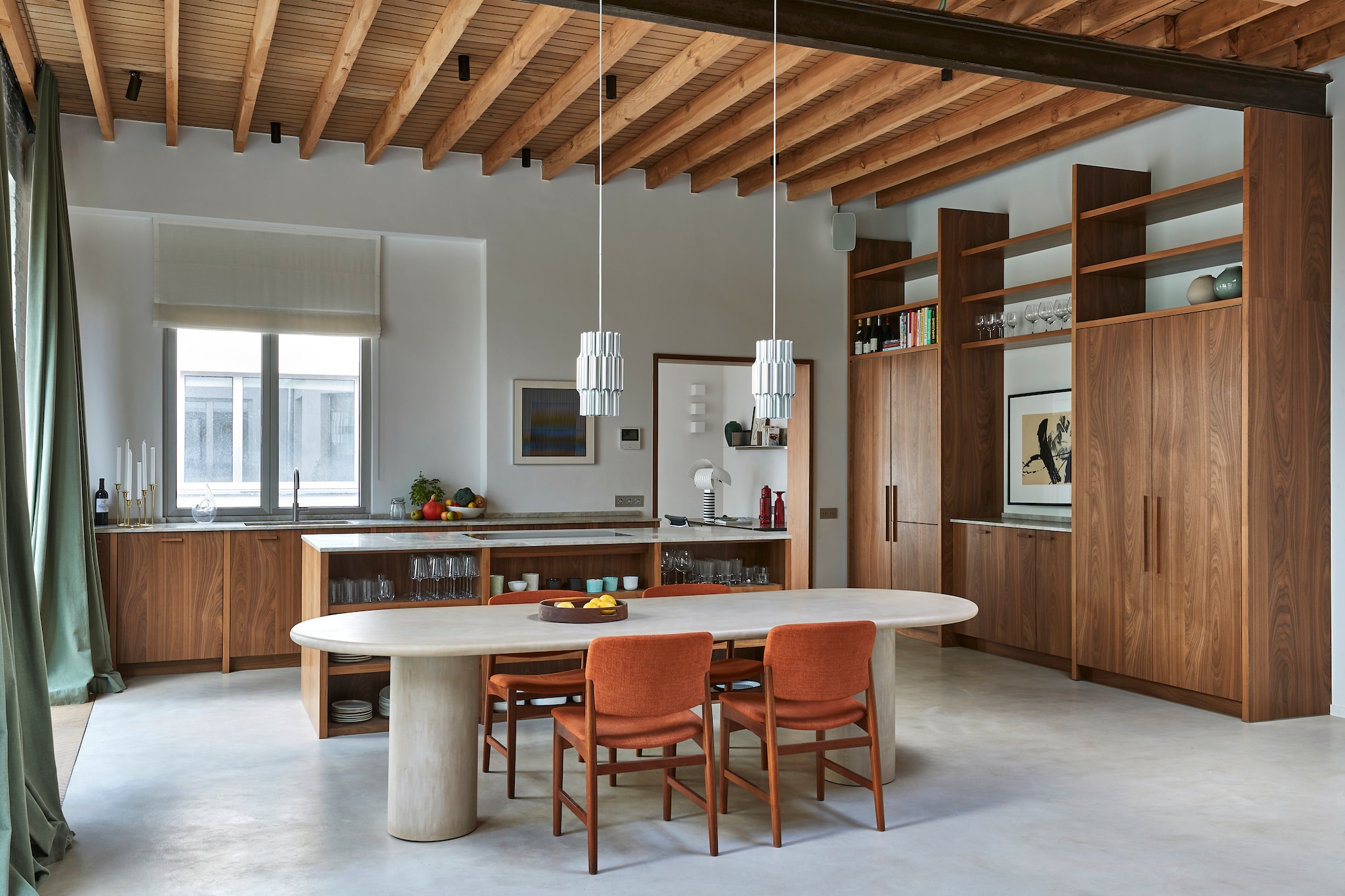 In de hele loft is walnoothout gebruikt voor het timmerwerk. De kasten in de open keuken verbergen zowel een koelkast als opbergruimte. Maatwerk eettafel van mortex. Hanglampen Lyfa. vtwonen design 8-2026 | productie living inside | fotografie jan verlinde