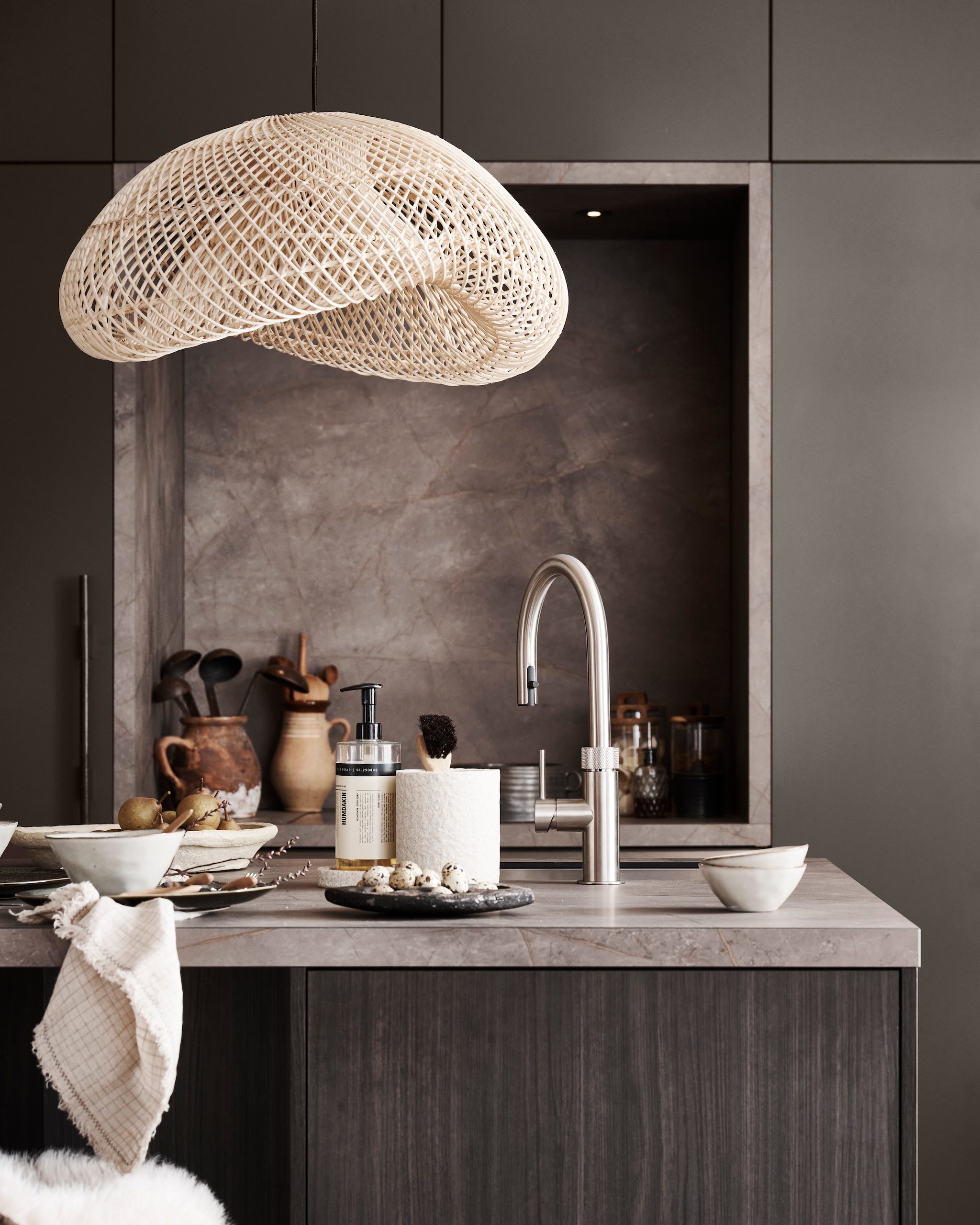 vtwonen x Mandemakers Tricolore keuken in agaatgrijs zarahome.com (hangend dienblad, vloerkleed, tafelkleed, schapenvachten, servetten), hetkabinet.nl (stoel, kruk), hkliving.com (barkrukken), loods5.nl (vaas), rawmaterials.eu (hanglamp). vtwonen 13-2024 | styling Kim van Rossenberg | fotografie Sjoerd Eickmans