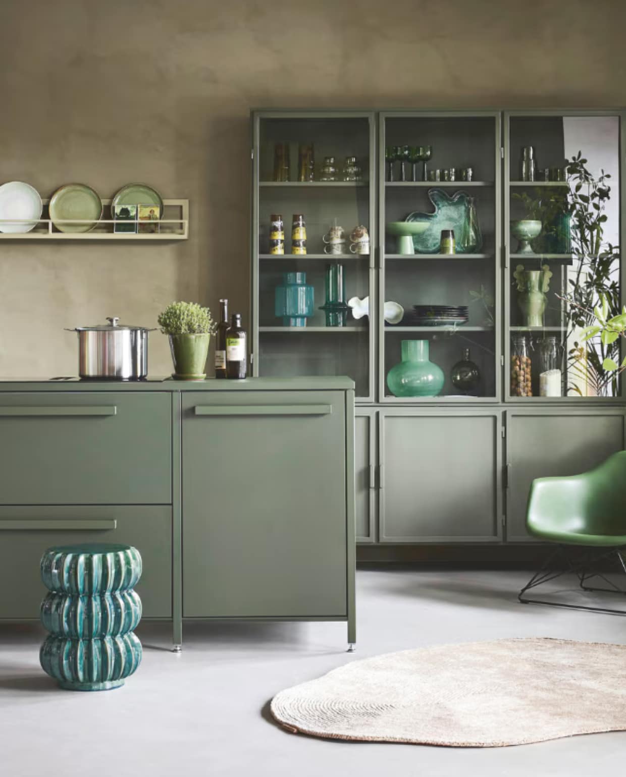 Lab Paint kalkverf, links Limited Jade en rechts Tokyo Tea, 1 liter € 66,-(vestingh.nl). Keuk keuken, groen bovenblad, met basisapparatuur vanaf € 5000,- (keuk.nl). New Routz buffetkast Garland, metaal, olijfgroen, 183x43x222 cm (bxdxh) € 2495,-, Pstr Store poster Woodblock Print III, papier, wit en groen, 70x100 cm € 83,-, poster Grove van Marco Marella, papier, wit en groen, 50x50 cm € 58,- (shop.vtwonen.nl). Vitra loungestoel Lar, kunststof en metaal, 62,5x61x63,5cm (bxdxh) € 565,- (loods5.nl). Casalis vloerkleed, textiel, naturel, prijs op aanvraag (casalis.be). Polspotten bijzettafel Pumpkin, aardewerk, groen € 220,- (polspotten.nl). Servies in de kast en op het schap: HKliving hoge glazen 70’s L, groen, set van 4 € 39,-, glazen 70’s bulb, lichtgroen, set van 4 € 30,-, wijnglazen, groen, set van 4 € 46,95, laag glas Tube, olijfgroen € 8,50, karaf Tube, olijfgroen € 19,95, bekers, aardewerk, geel en bruin € 19,95, koffiekop met oor, aardewerk, bruin € 8,75, beker, aardewerk, groen en bruin € 7,50, schaal op voet The Emerald, aardewerk, groen € 54,99, schaaltje Oyster, aardewerk, groen € 25,-, schaal Shell, aardewerk, blauw en groen € 72,-, schaal op voet, aardewerk, privébezit, bord 70’s, aardewerk, zachtgroen € 27,95, bord Chef, groen € 15,-, bord The Emeralds, donkergroen € 24,95, hanglamp Ceramic, aardewerk, oker € 149,- (hkliving.nl). Urban Nature Culture vaas, gerecycled glas, transparant € 14,99, vaas,gerecycled glas, flessengroen € 29,99, vaas Collo Reseda M, glas, lichtgroen € 39,95, kandelaar Sopra, bol glas, olijfgroen € 24,99 (shop.vtwonen.nl). Ansichtkaarten € 1,- (artunlimited.nl). Ikea pan Hemkomst, aluminium € 49,95, voorraadpot Korken in de kast € 2,79 (ikea.com). Theedoeken, katoen, groen en wit € 7,95 (dille-kamille.nl). Planten met pot en oude schaal op voet privébezit. vtwonen 09-2025 | styling Marianne luning | fotografie Alexander van Berge