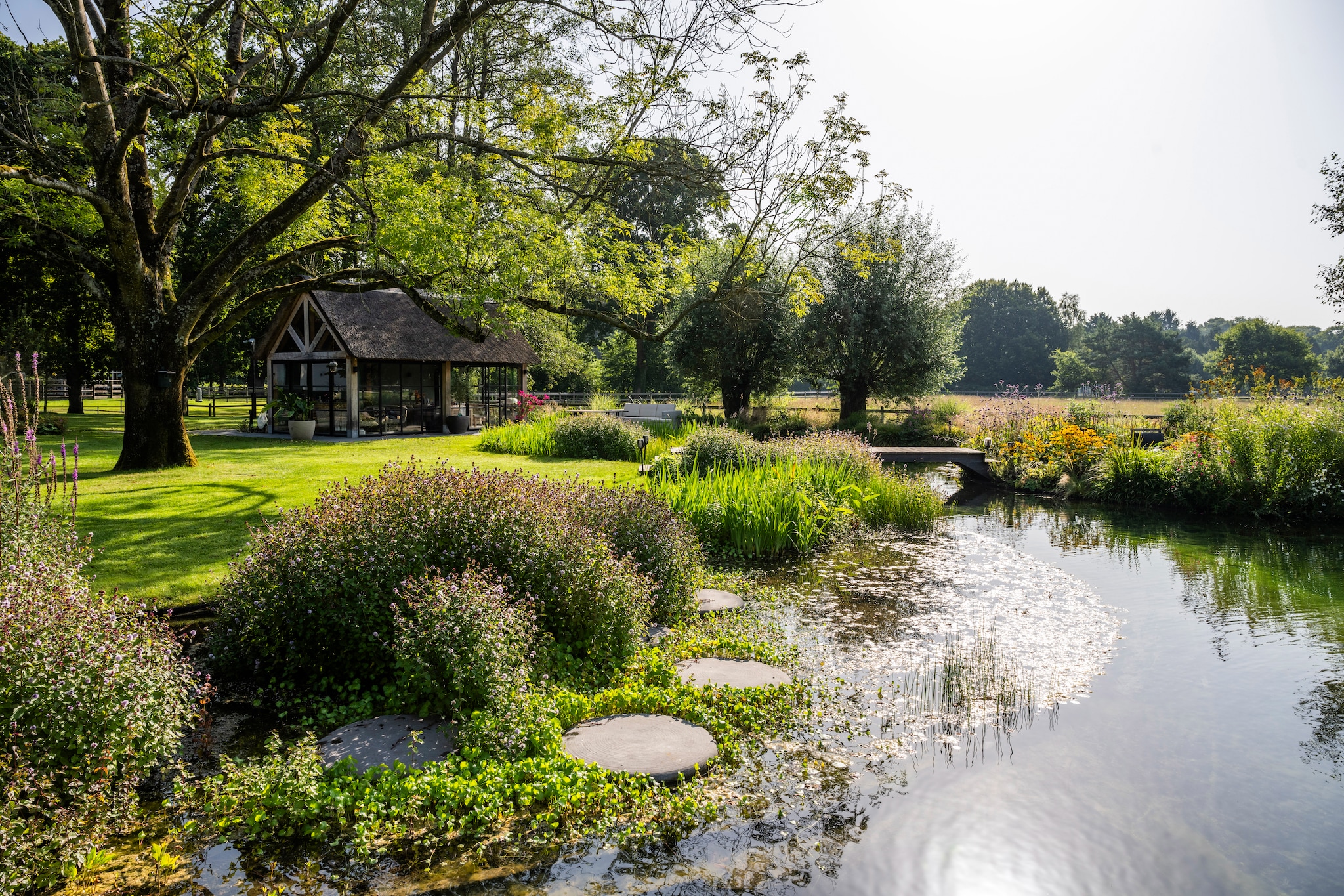 Aangelegde tuin met zwemvijver, terrassen, prieel met rieten dak en beplantingsplan door Meeuwis de Vries Tuinen, prijs op aanvraag (meeuwisdevries.nl). vtwonen Landelijk 08-2026