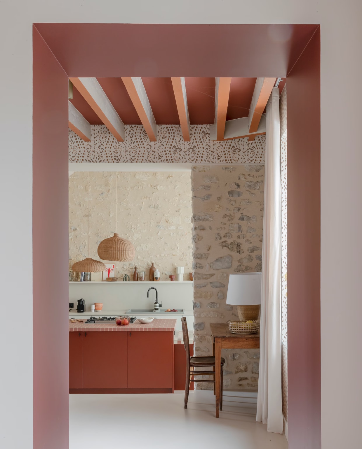 Keuken Snaidero. Eiland Valdesign. Kastdeurgreepjes Dauby. Beton ciré-vloer Ad Lucem. Gootsteen Blanco. Tegels Winckelmans. Hanglampen en tafellamp Ferm Living. Behang Les Touches van Brunschwig & Fils. Tafel en stoel vintage.